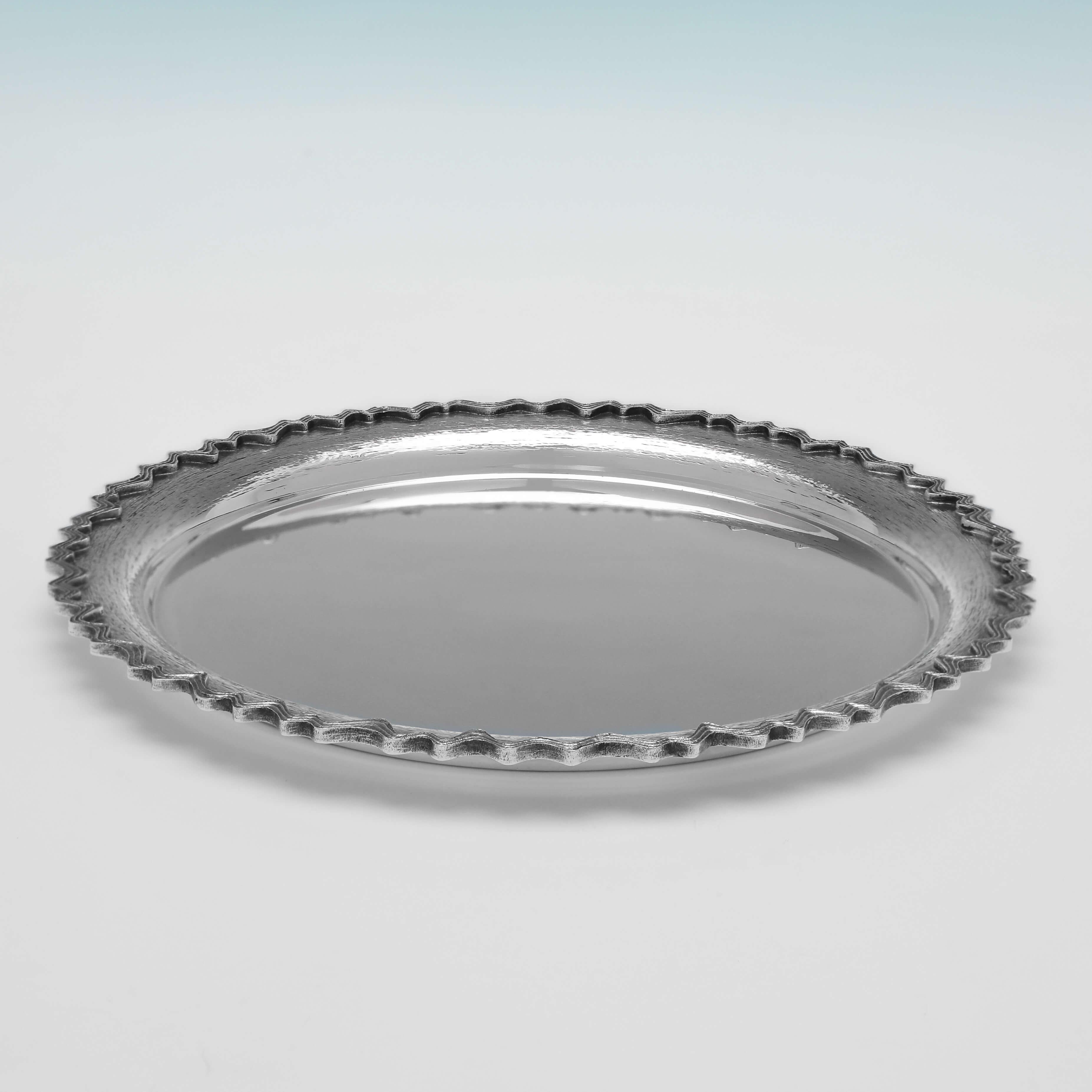 Hallmarked in London in 1975 by Christopher Lawrence, this stylish, Sterling Silver Dish, features a cast shaped border, and textured detailing. The dish measures 8
