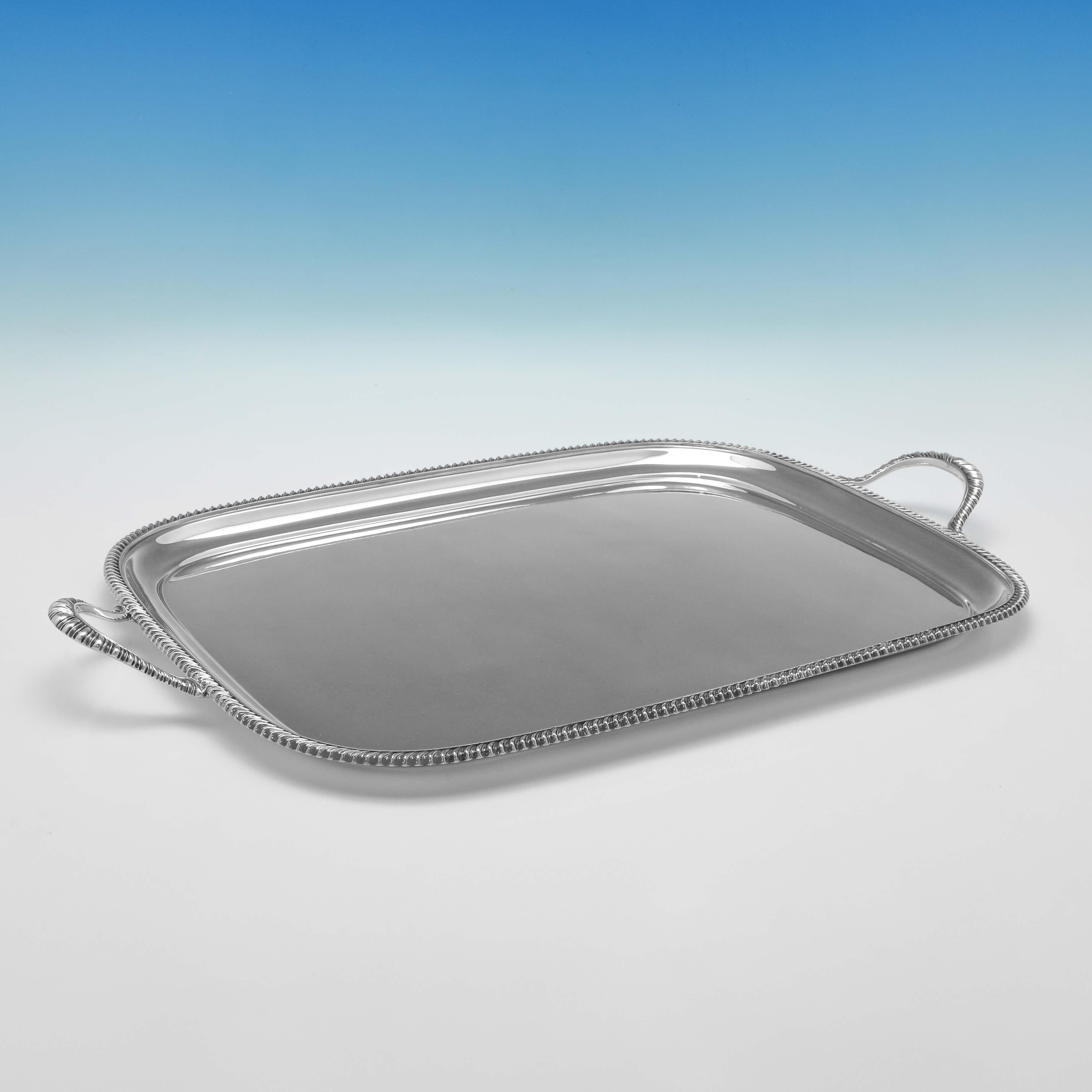 Hallmarked in Sheffield in 1952 by Atkin Brothers, this handsome, Sterling Silver Tray, features a gadroon border to the rim and handles. 

The tray measures 1.35