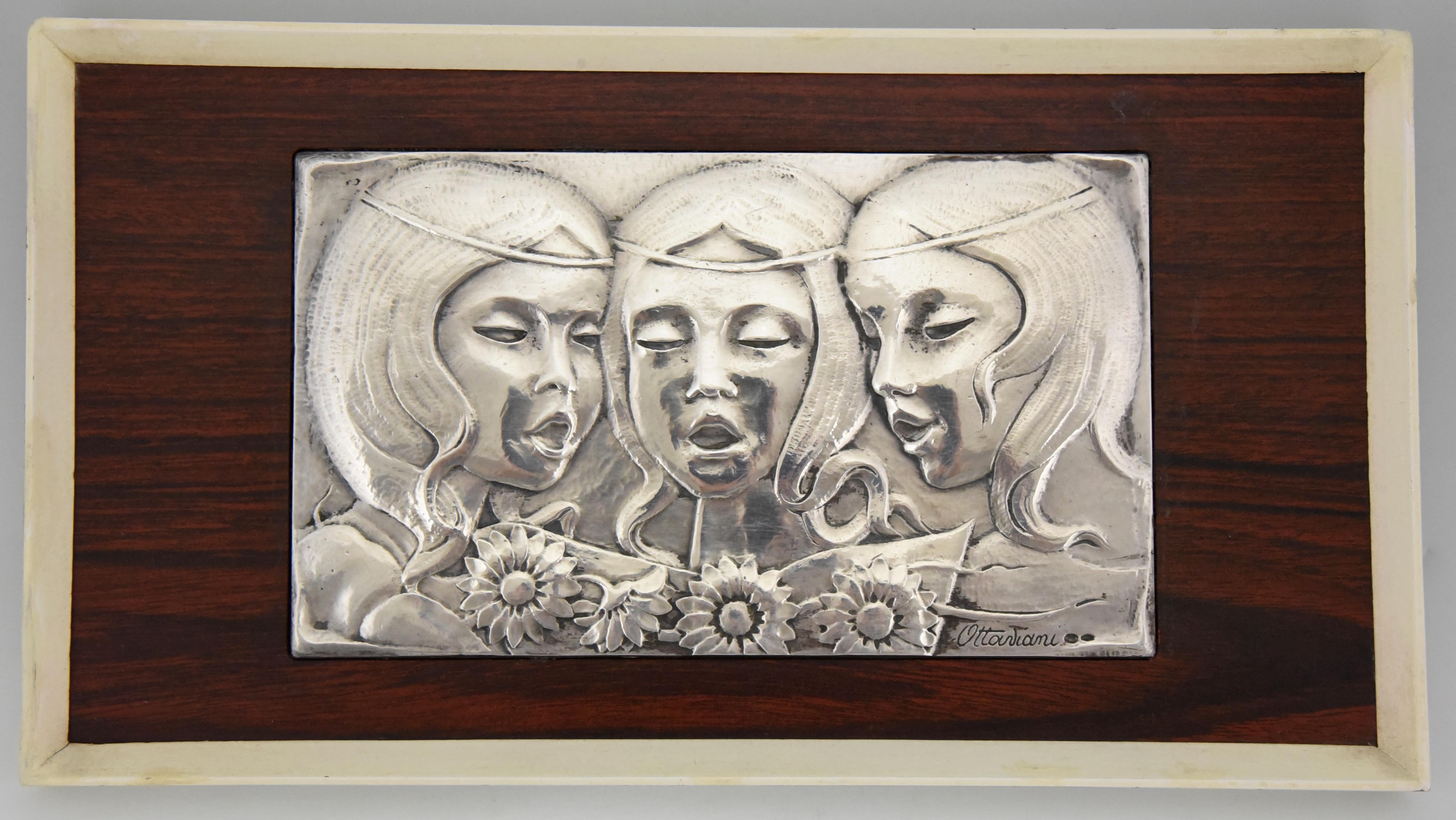 Precioso panel mural de plata de ley de mediados de siglo 3 niñas cantando con flores. Firmado por el platero italiano Ottaviani, 1960. 
Ottaviani (1945) es una empresa de joyería y platería situada en la pequeña ciudad costera de Recanati, Italia.