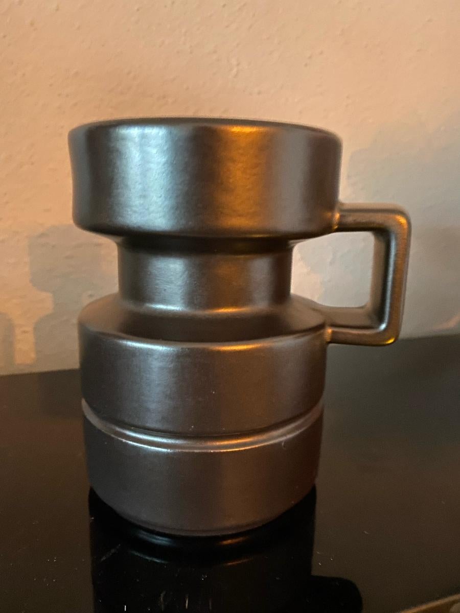 Designed by Cari Zalloni and produced in the 1960's or 1970's at Steuler, this deep dark brown candleholder stands 15cm (6 inches) tall and has a diameter of 10cm (4 inches). The base of the candleholder is embossed with the Steuler logo and the