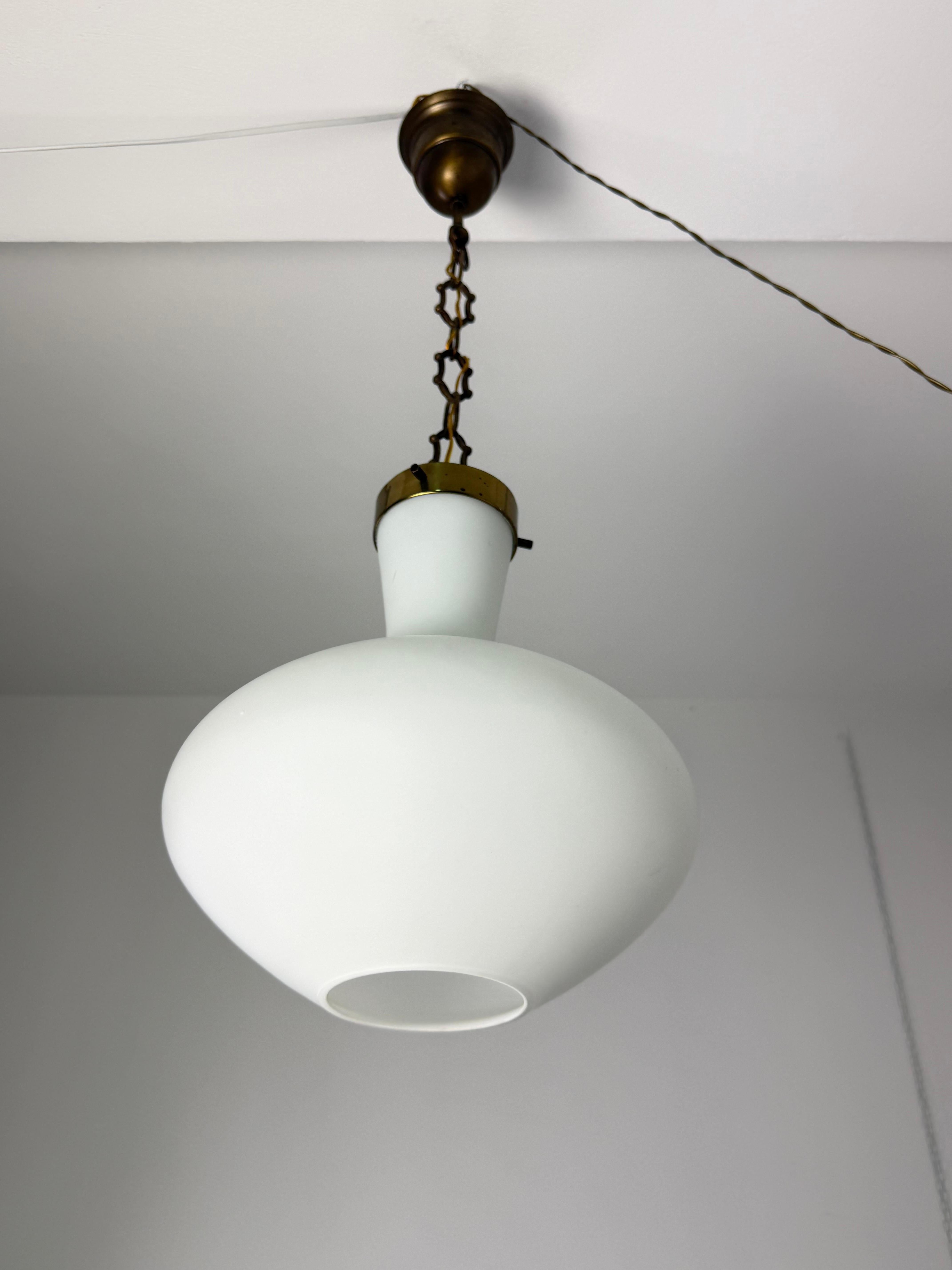 Lampadario in ottone e vetro opalino Stilnovo di metà secolo, anni '50
Condit e in buone condizioni, attacco per lampadina E27.

Marchio del produttore.

Altezza: 35 cm (80 cm con catena al soffitto), diametro 33 cm.

Garantiamo una spedizione