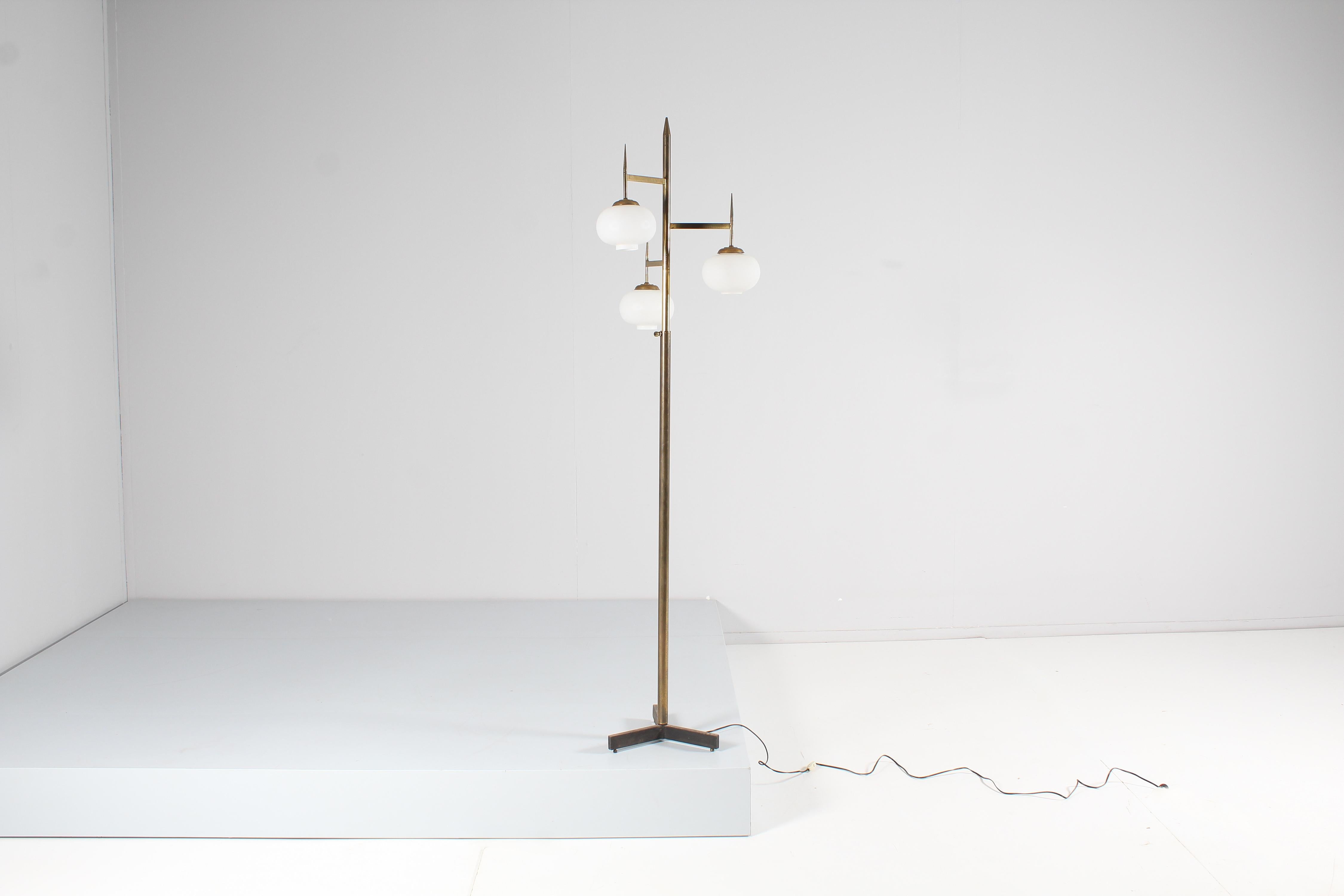 Very elegant floor lamp adjustable in height by means of a screw knob, with brass structure and three arms at staggered levels with satin white glass diffusers. Italian production attributed to Stilnovo, in the 1950s.
Wear consistent with age and