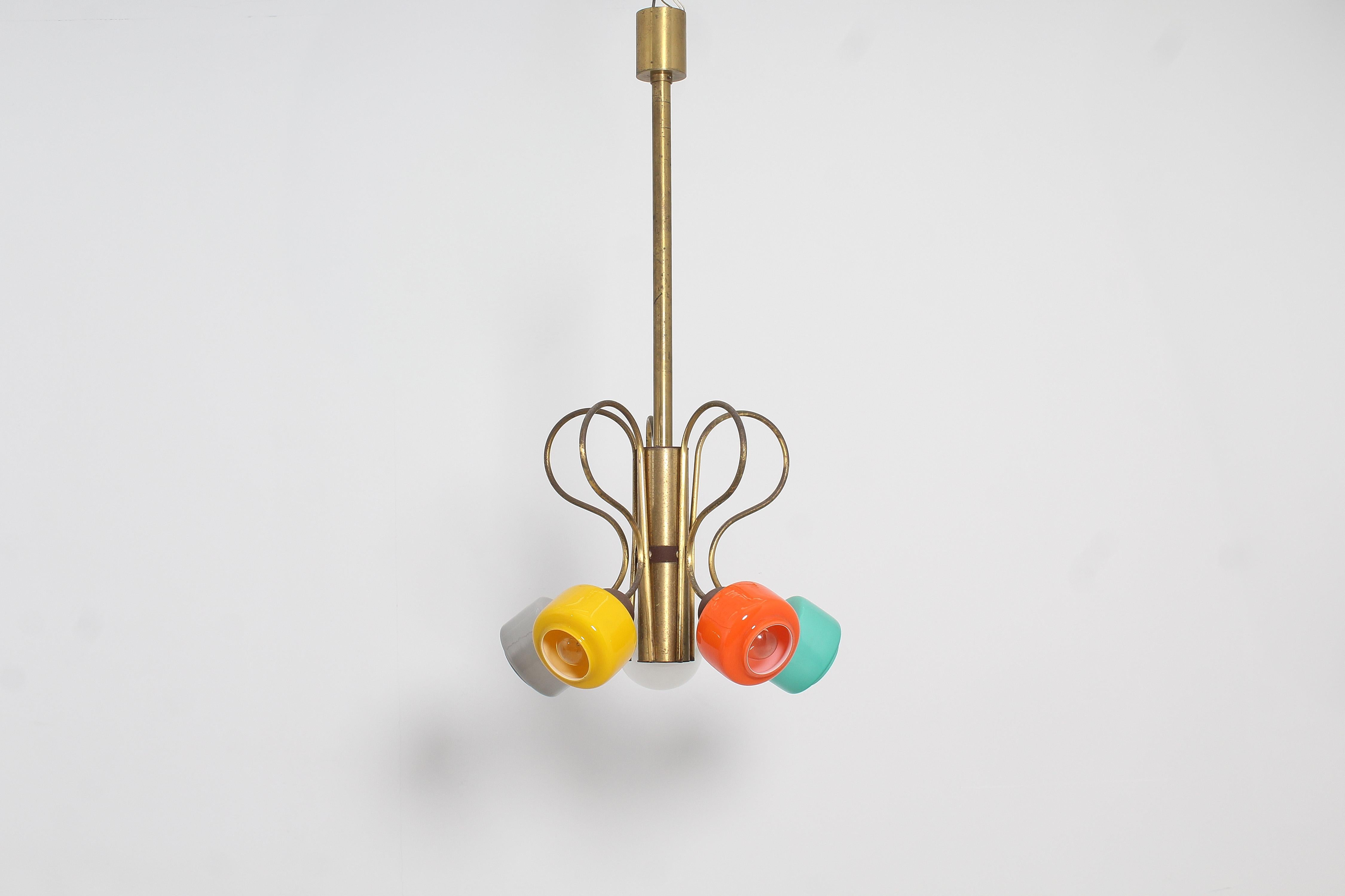 Captivating chandelier with five rigid arms in curved golden brass rod, with colored murano glass diffusers. The arms are anchored to a brass cylinder. Attributed to Stilnovo, Italy 1960s.
Wear consistent with age and use.