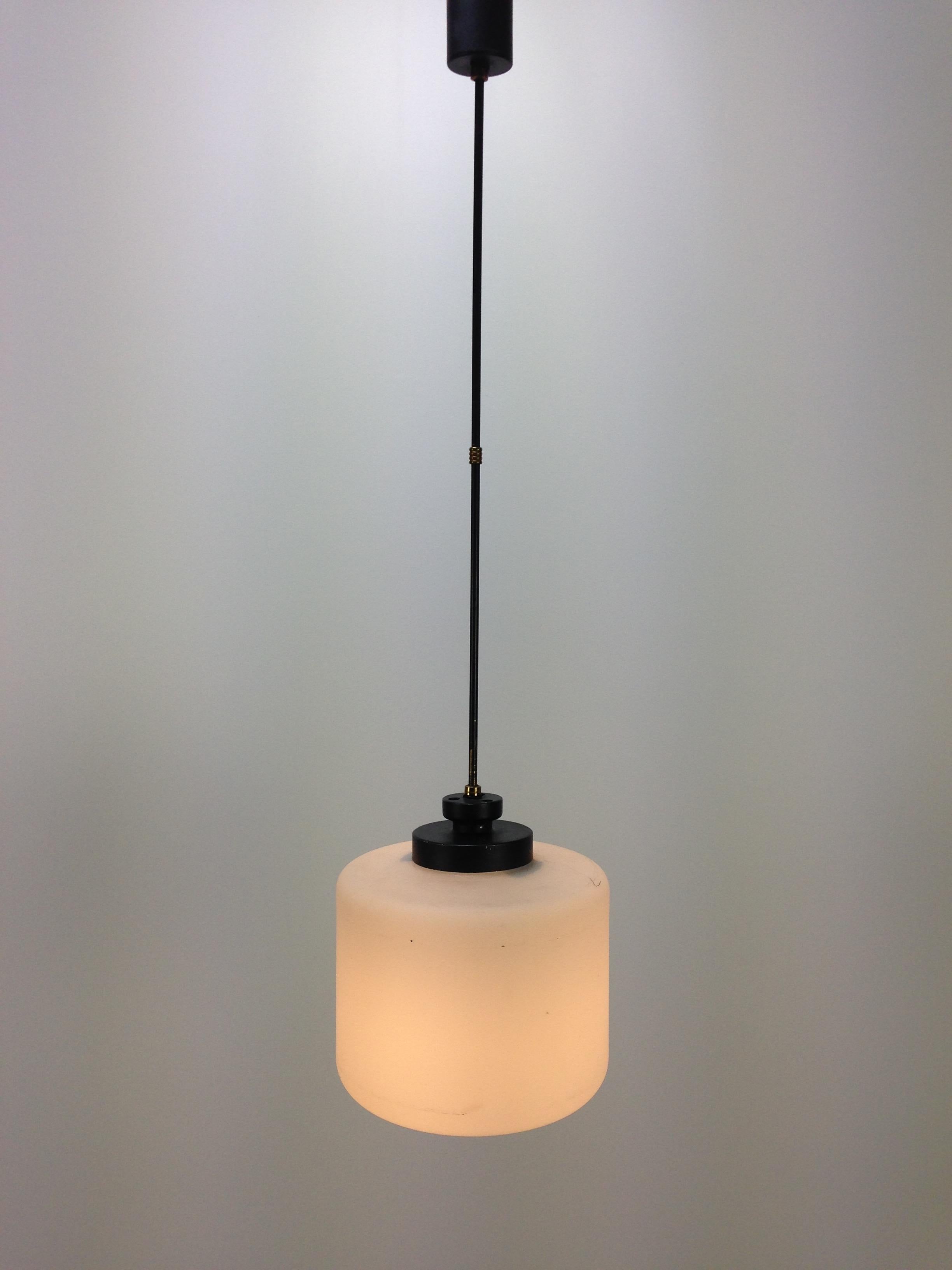 Very nice Italian pendant fabricated by Stilnovo in the 1950s.

A beautiful hand blown glass shade in milk glass combined with a brass and black metal body.

Very good vintage condition, no cracks or chips.  
The wiring has been checked by a