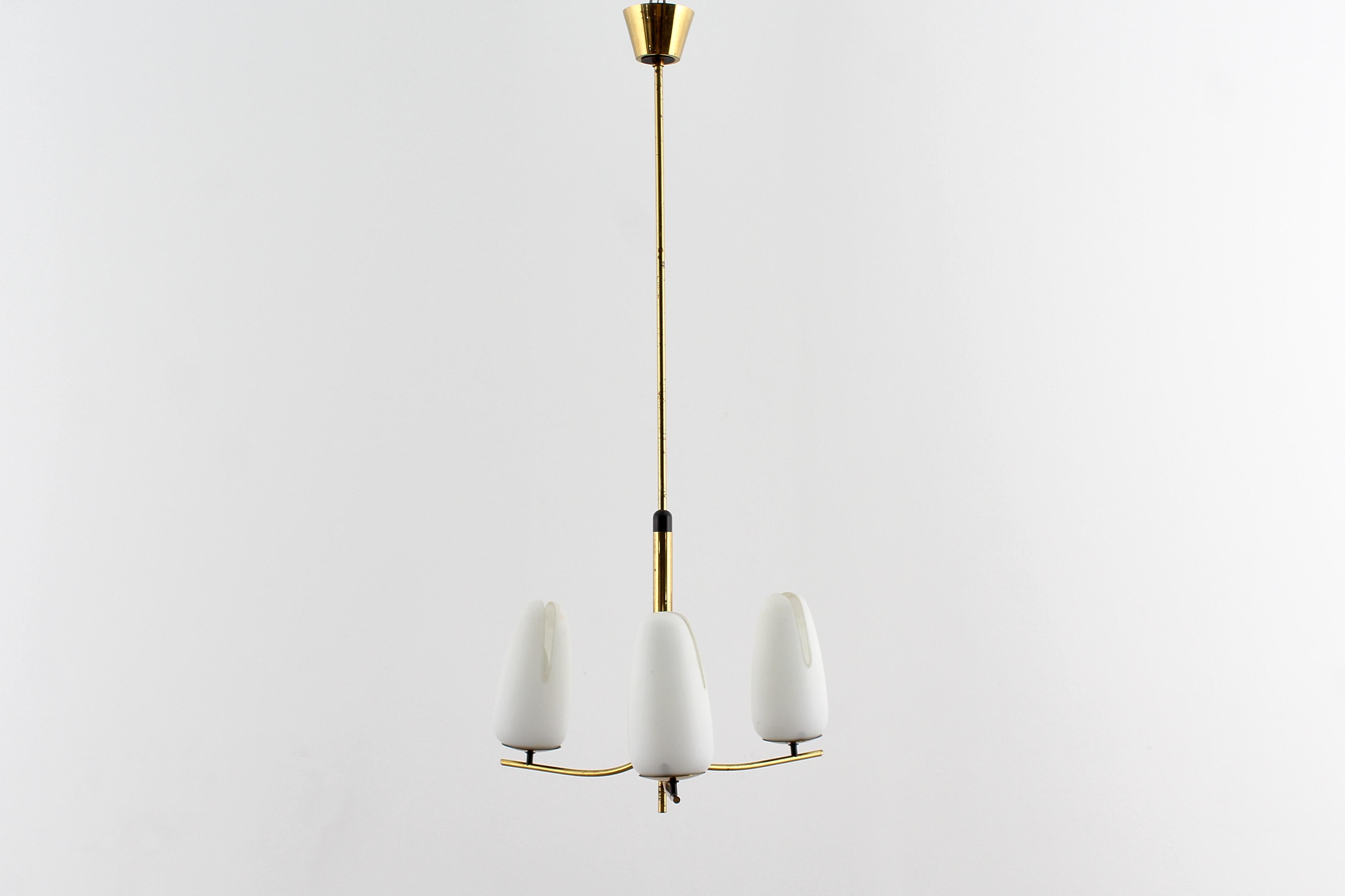 Elegante lampadario a tre luci in ottone con diffusori in vetro opalino. Nello stile di Stilnovo, produzione italiana degli anni '50.
Se coerente con l'età e l'uso.