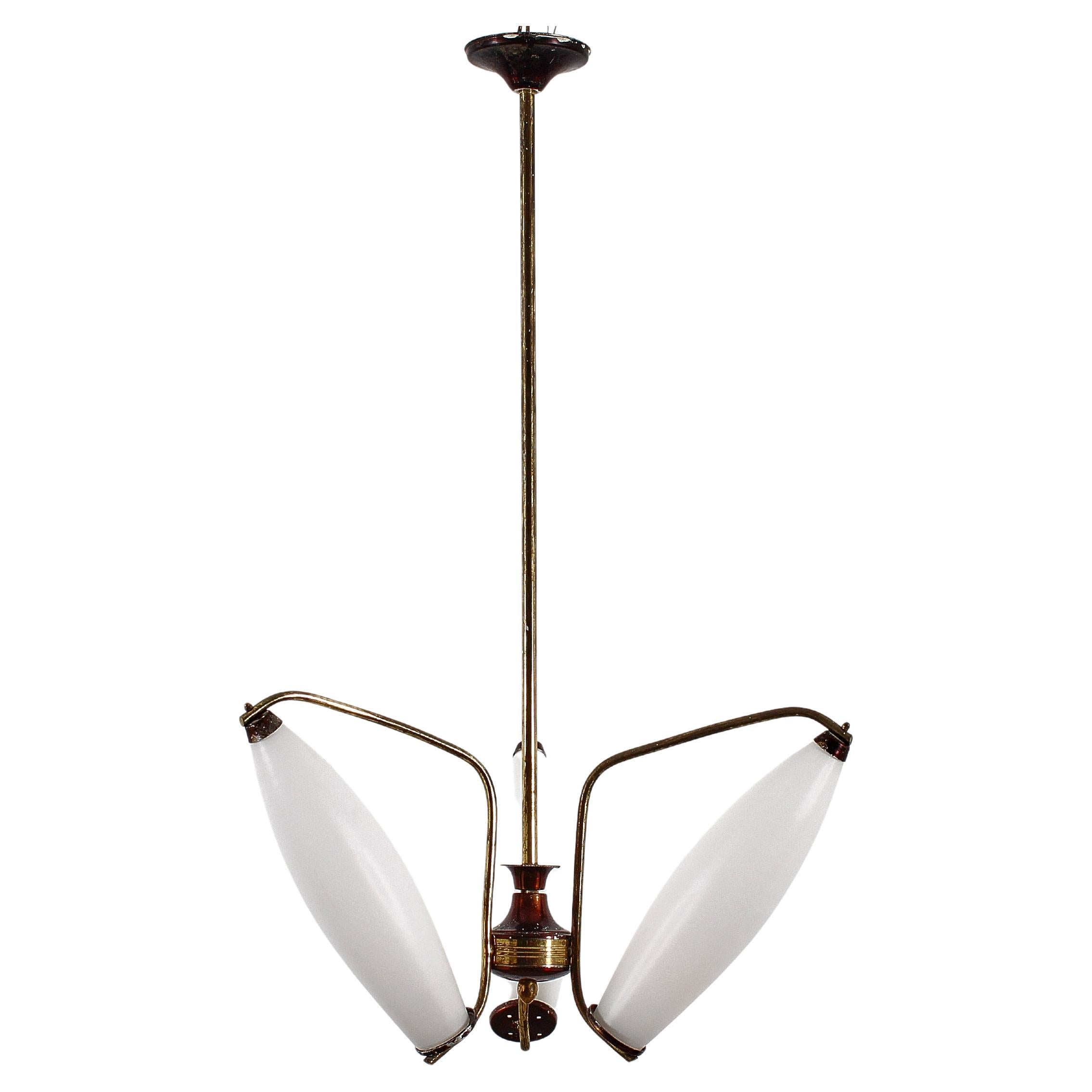 Bellissimo lampadario a tre luci in ottone con diffusori in vetro opalino, nello stile dello Stilnovo, produzione italiana degli anni Cinquanta. Se coerente con l'età e l'uso.
