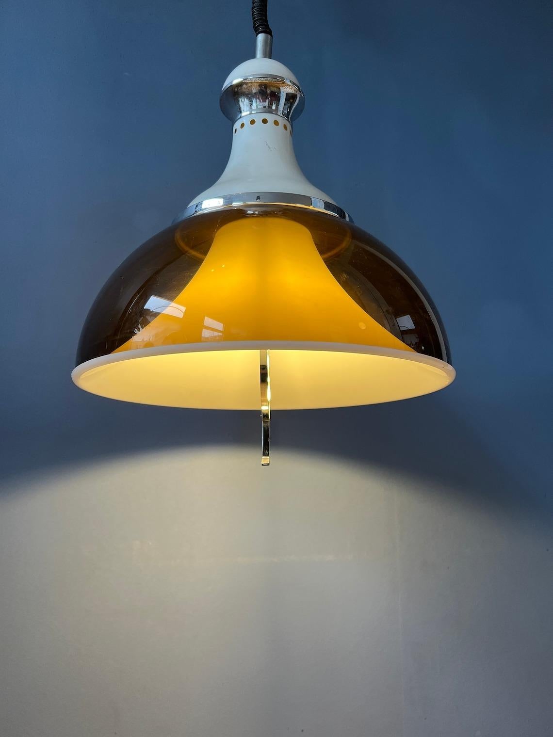 Mid century Stilux Milano space age pendant lamp with double acrylic glass shade. The lamp consists of an acrylic glass copper coloured outer shade and a white inner shade. The height of the lamp can be adjusted with the rise-and-fall system. The