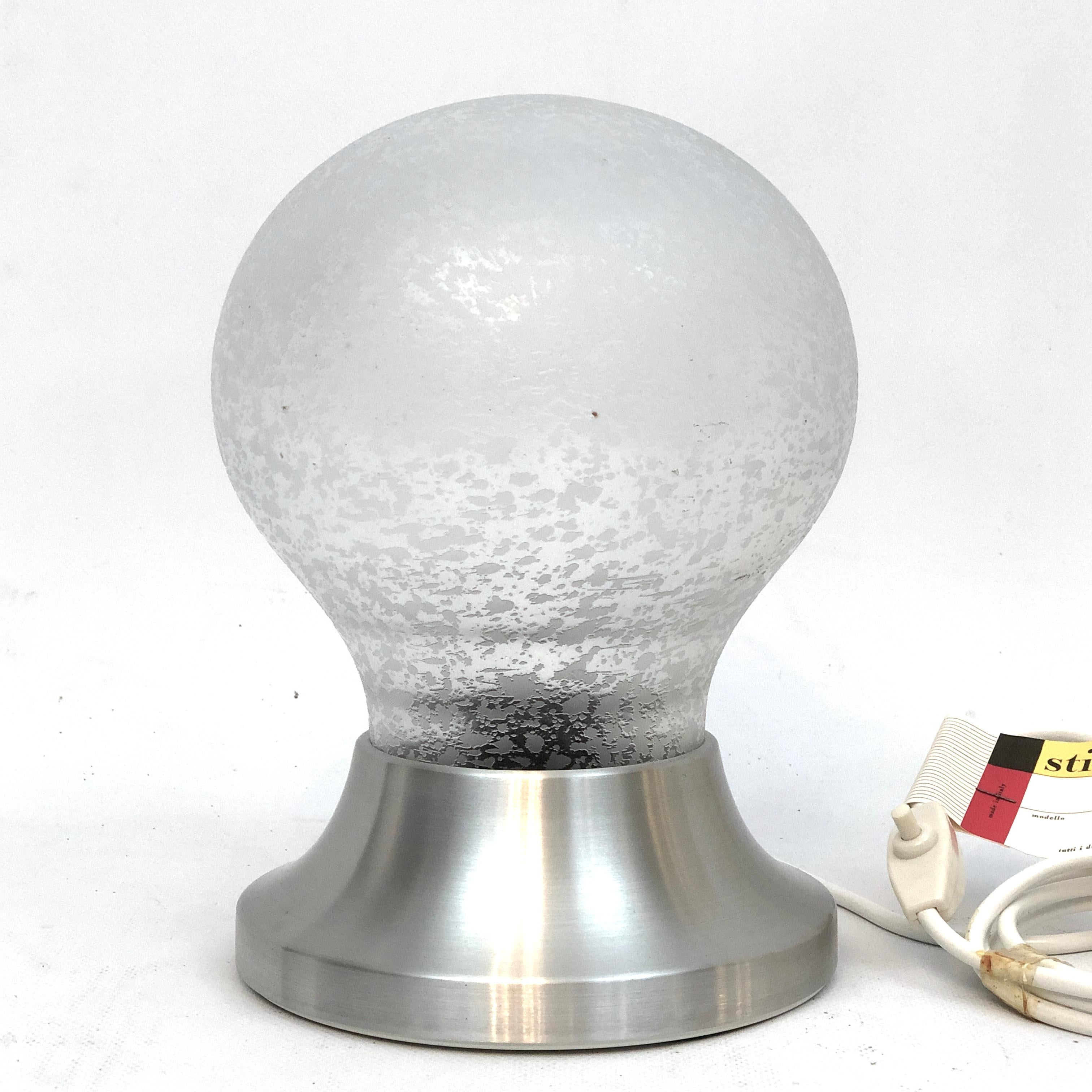 Vintage jamais utilisé en état original avec label et étiquette pour cette lampe de table en verre dépoli et aluminium produite par Stilux Milano pendant les années 60. Fonctionne entièrement avec la norme européenne, adaptable sur demande à la