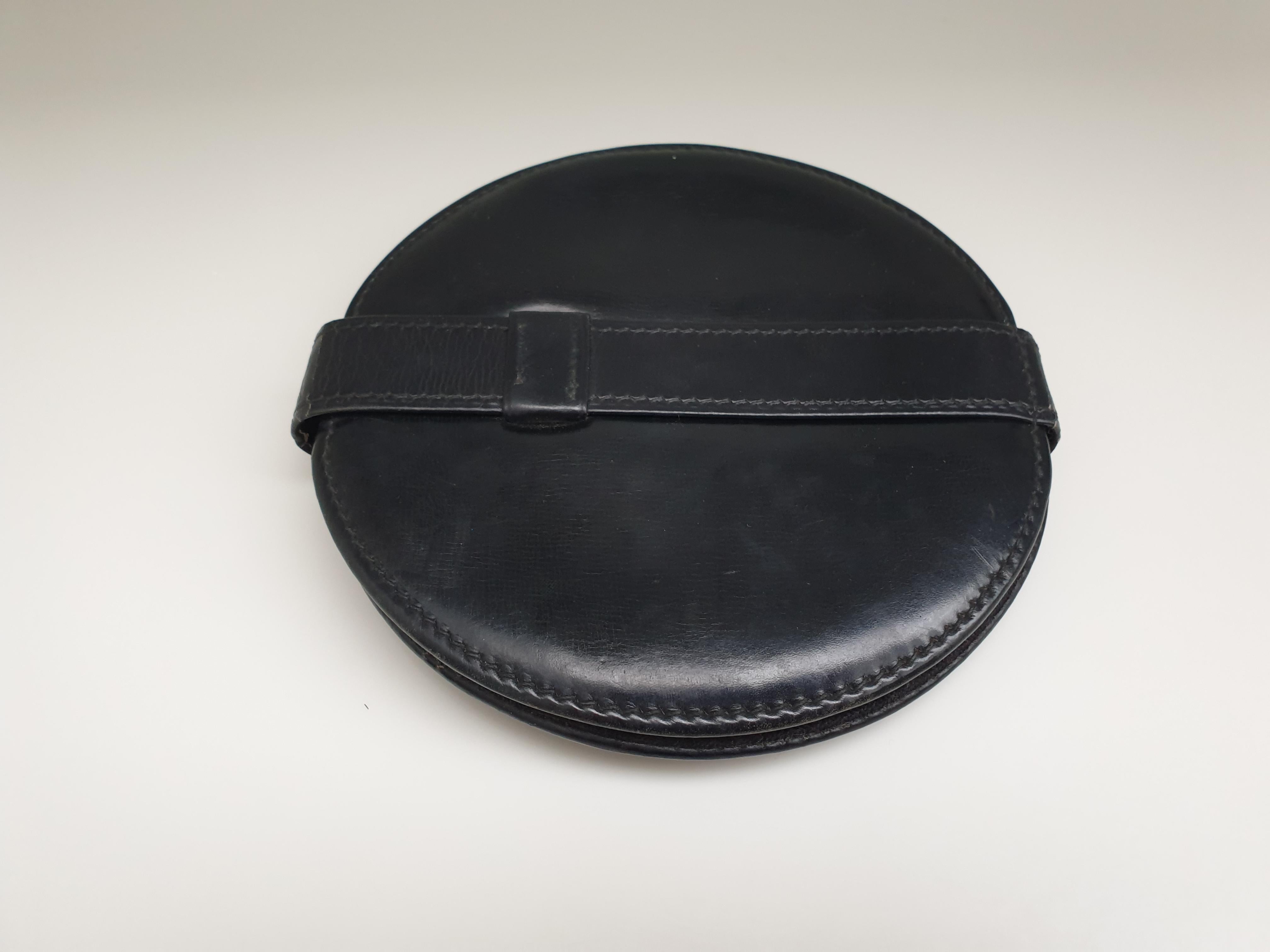 Useful travel mirror in black stitched leather, attributed to Jacques Adnet.  This folding, leather framed mirror has one distressed mirror and on replaced mirror so it is eminently usable. The exterior frame is black stitched leather and the