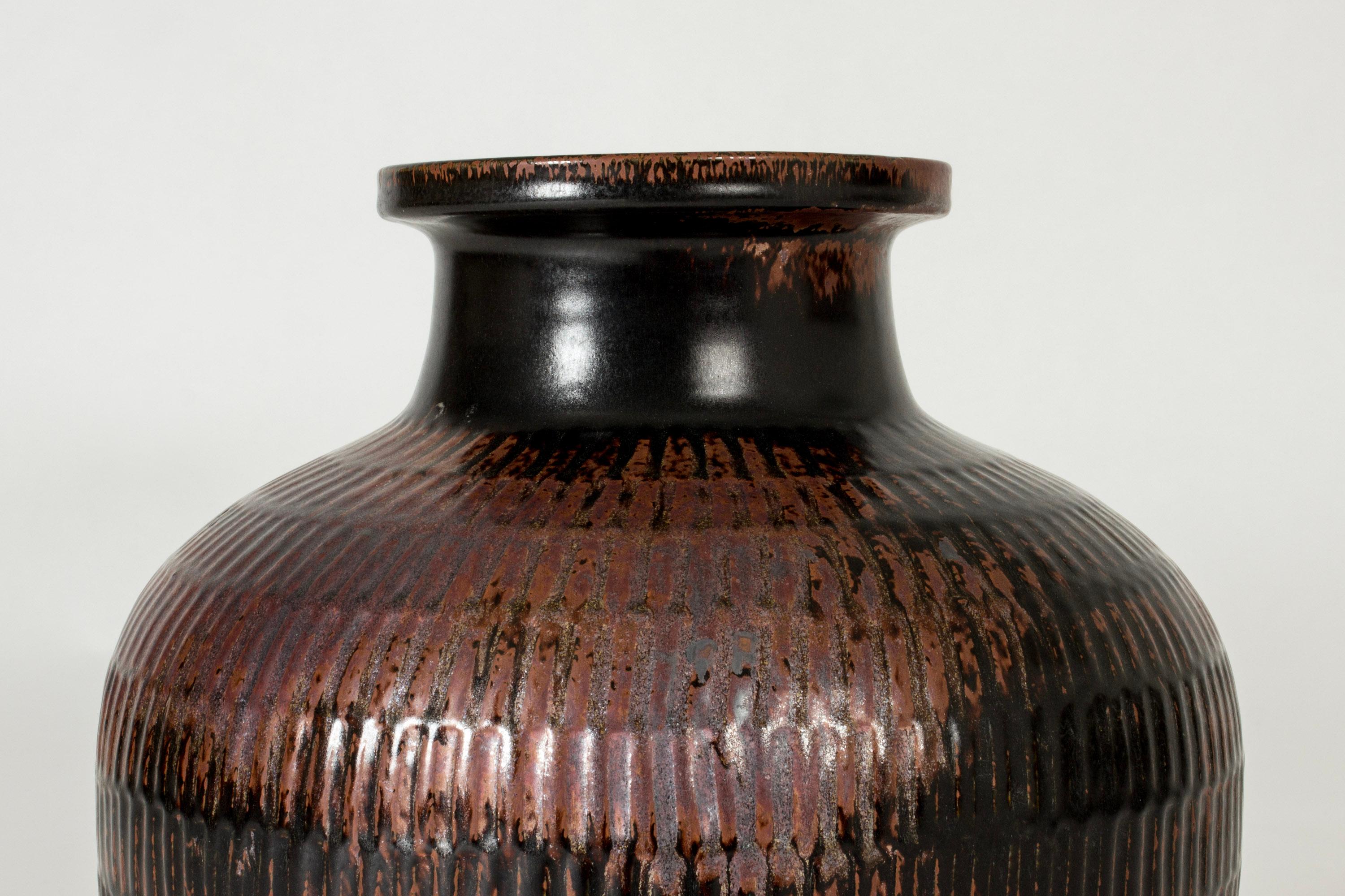 Stoneware floor vase by Stig Lindberg, in a plump form and imposing size. Graphic striped pattern, rich brown tenmoku glaze.