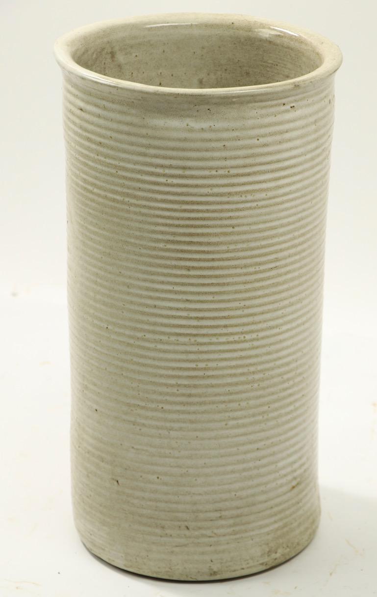 Stoneware umbrella or cane holder of cylindrical form with textured ribbed surface. Sophisticated architectural design, organic and earthy tone and finish. No damage, chips, cracks or repairs.