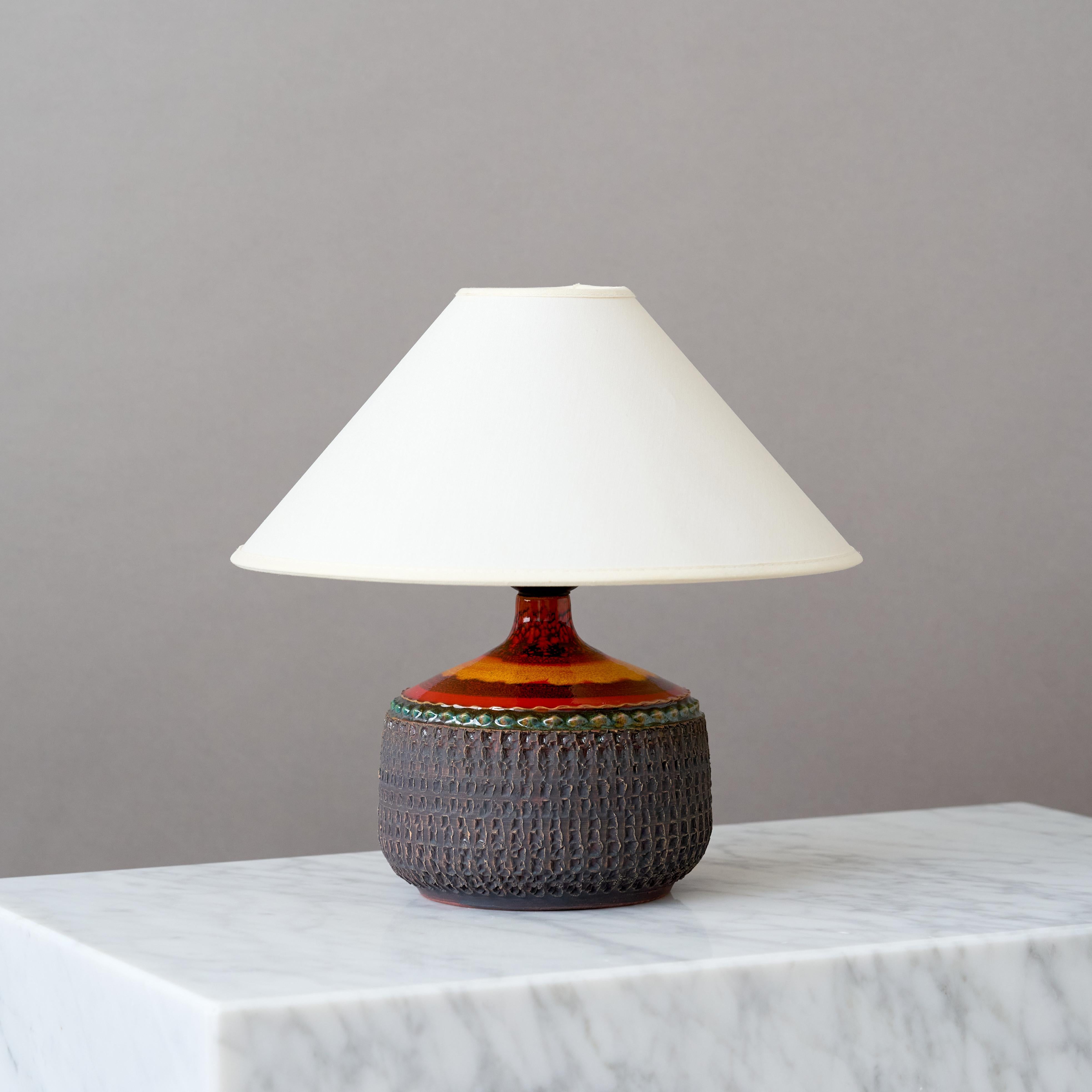A beautiful mid-century stoneware table lamp with amazing colorful glaze in red and orange.
Made by Otto Klaesson for Klase in Höganäs, Sweden, 1960s.

Great original condition. 
Signed 'Klase Höganäs' and 'Stengods'.

Sold without
