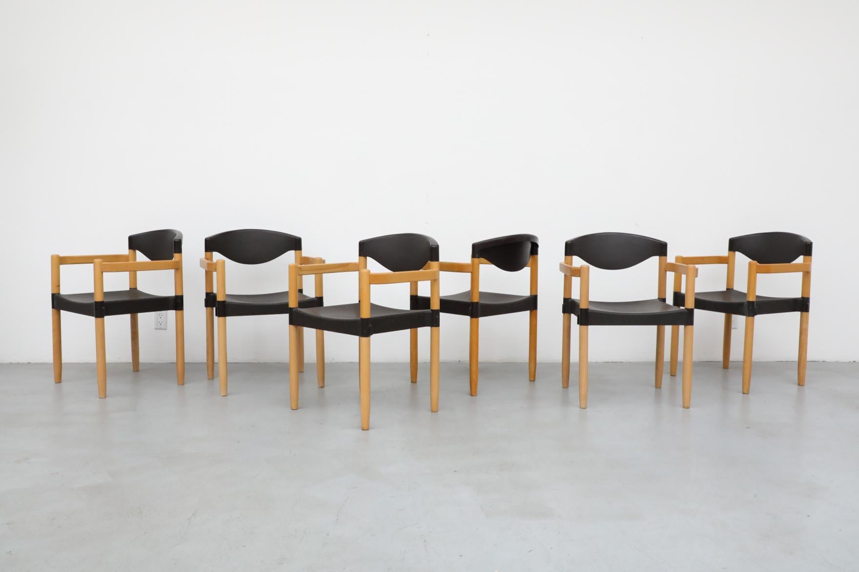 Mid-Century 'Strax' stacking arm chairs by Hartmut Lohmeyer for Casala, 1980s. Molded black plastic seat and back rest with tapered Birch legs designed to stack and interlock to make rows of seating. In original condition with visible wear and