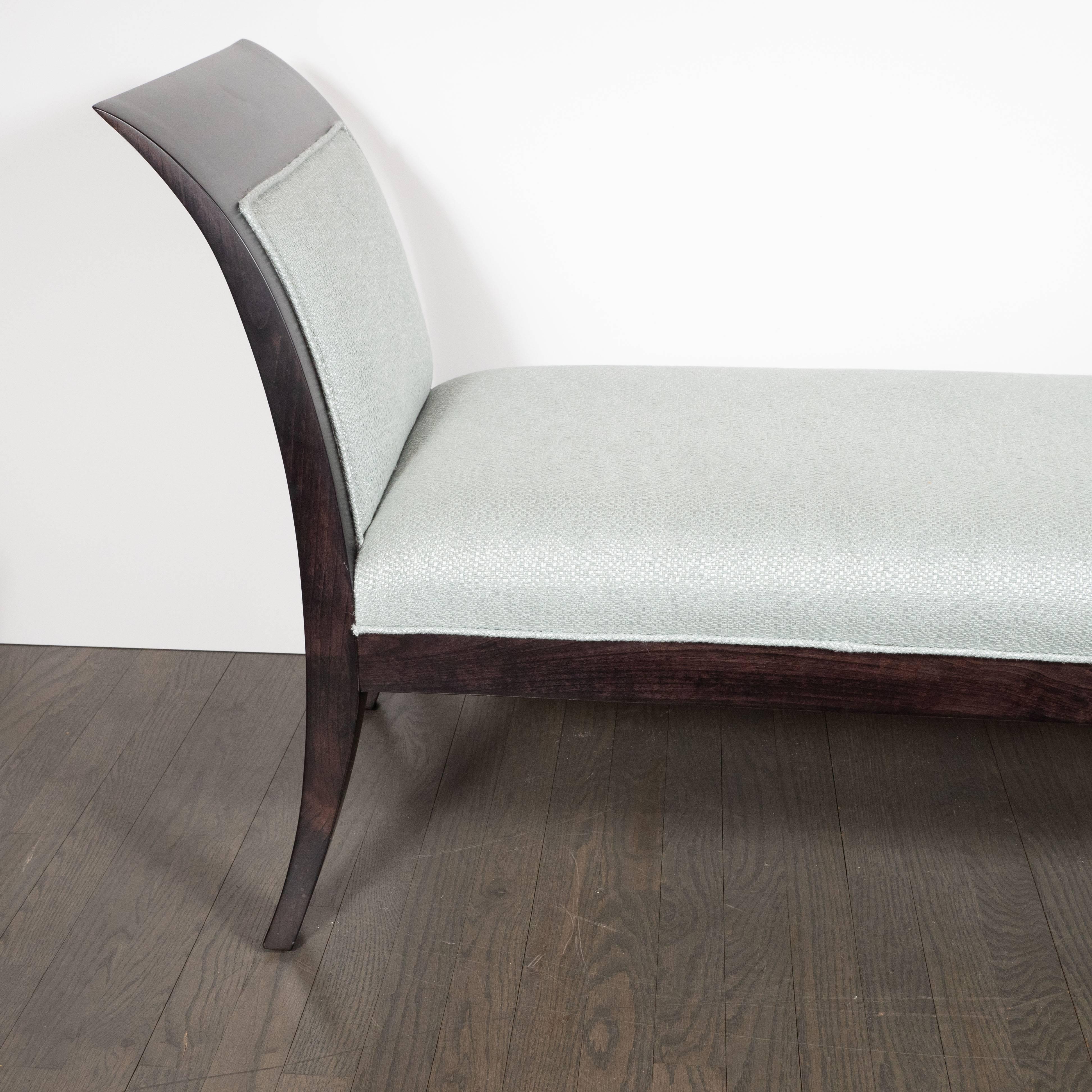 This sophisticated Mid-Century Modern bench features two streamlined sides in the United States, circa 1950. The bowed form of each side is reiterated in palindromic symmetry in the saber style legs upon which it rests, all realized in ebonized