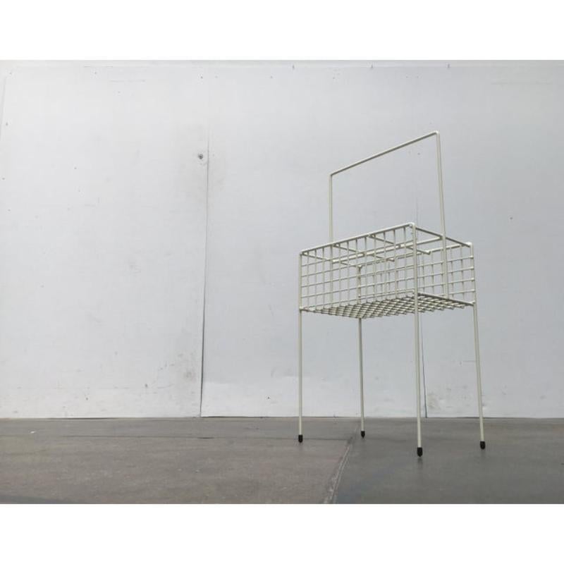Filigree bottle holder on legs. As a simple bottle holder or minimalist home bar.
Striking is the finely executed mesh of steel rods and the all-white color scheme. Above, the frame forms a bracket as a handle. Below, four filigree rods form the