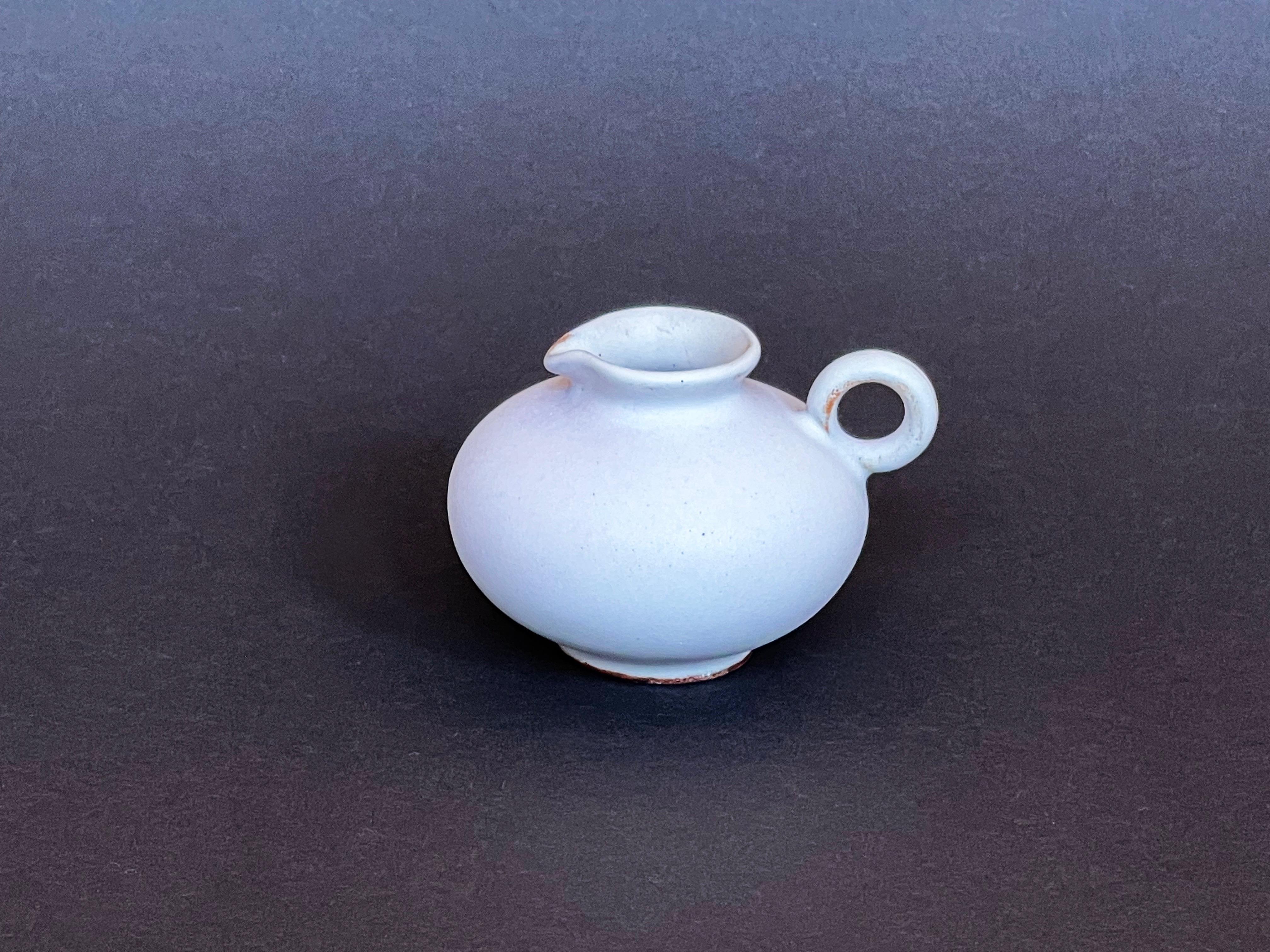 Wunderschöne kleine Keramikvase aus der Mitte des Jahrhunderts.
Ausgeführt von Marschner, um 1960 in Cuxhaven, Westdeutschland. 
Das winzige Gefäß hat eine recht neutrale und sehr ungewöhnliche mattweiße Glasur und einen exquisiten runden