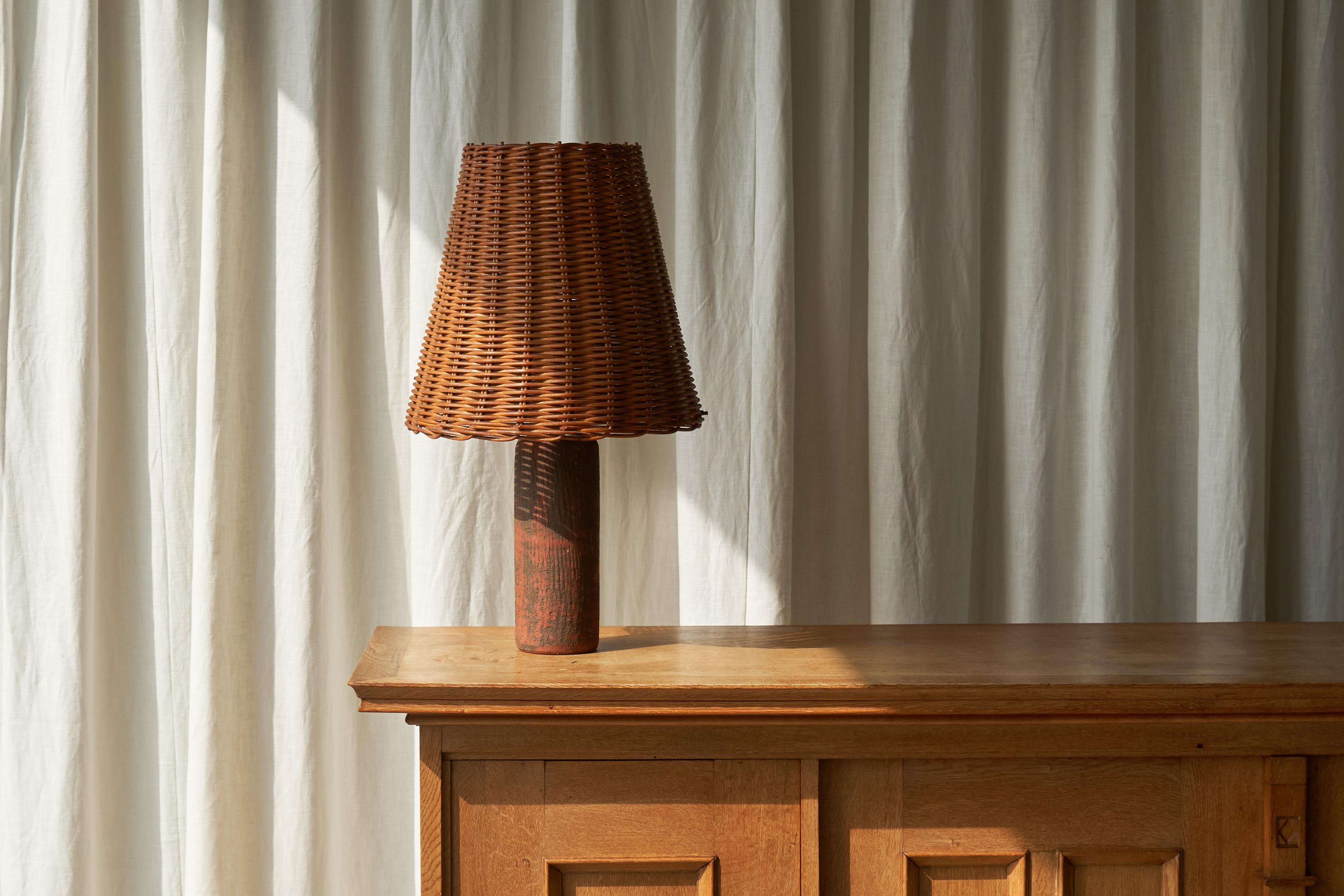 Mid Century Studio Pottery Tischlampe aus Schamotte-Ton mit Rattan-Schirm, Europa, 1950er Jahre.

Dies ist eine sehr charmante Mitte des Jahrhunderts Studio Keramik Tischlampe in Schamotte Ton mit Rattan Schatten. Es ist eine sehr schöne und typisch