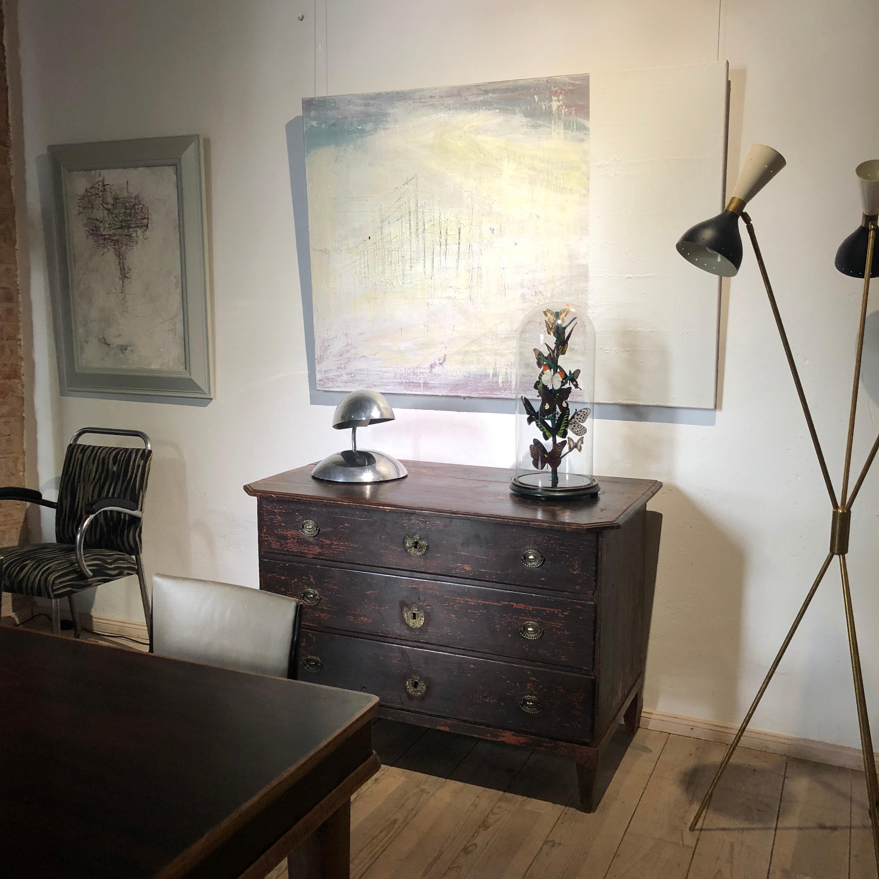 This floor lamp from Italy in the style of Stilnovo is in excellent condition and shows great patina.
It is composed of brass tripod legs joined in the middle with adjustable metal rods holding the black and white metal lampshades with two light