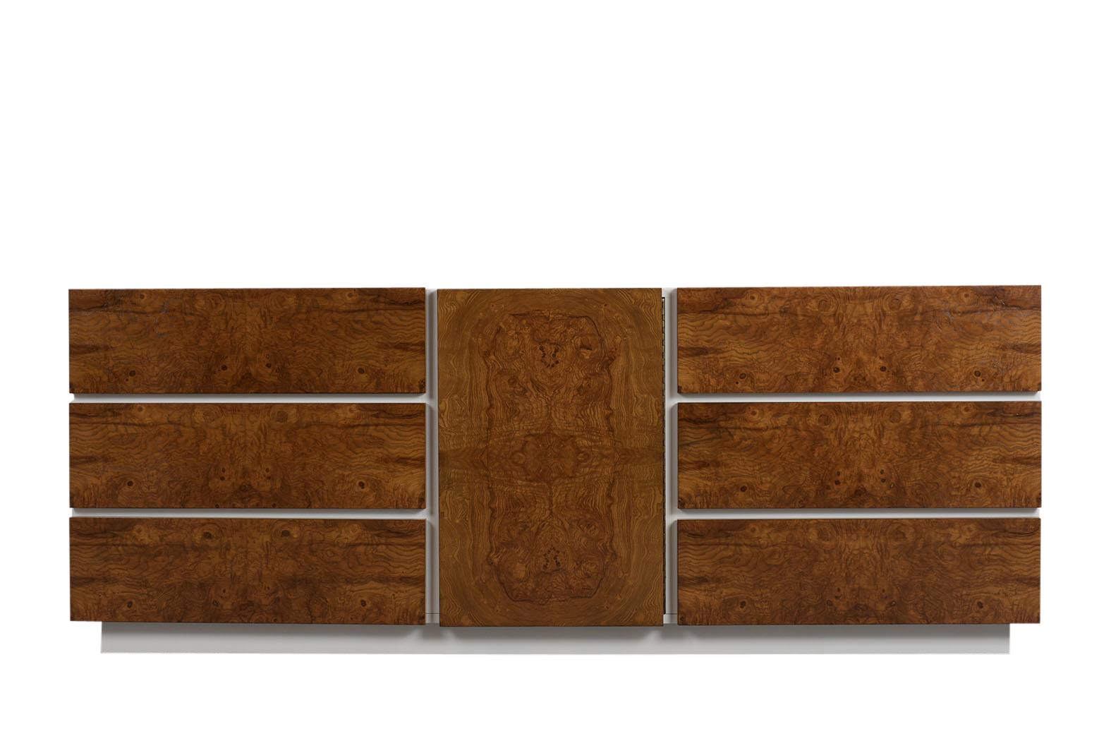 This 1960s mid-century burled elm sideboard has been professionally restored and is stained in a walnut and white color combination with a newly lacquered finish. The dresser comes with three large drawers on each side and a center door with three