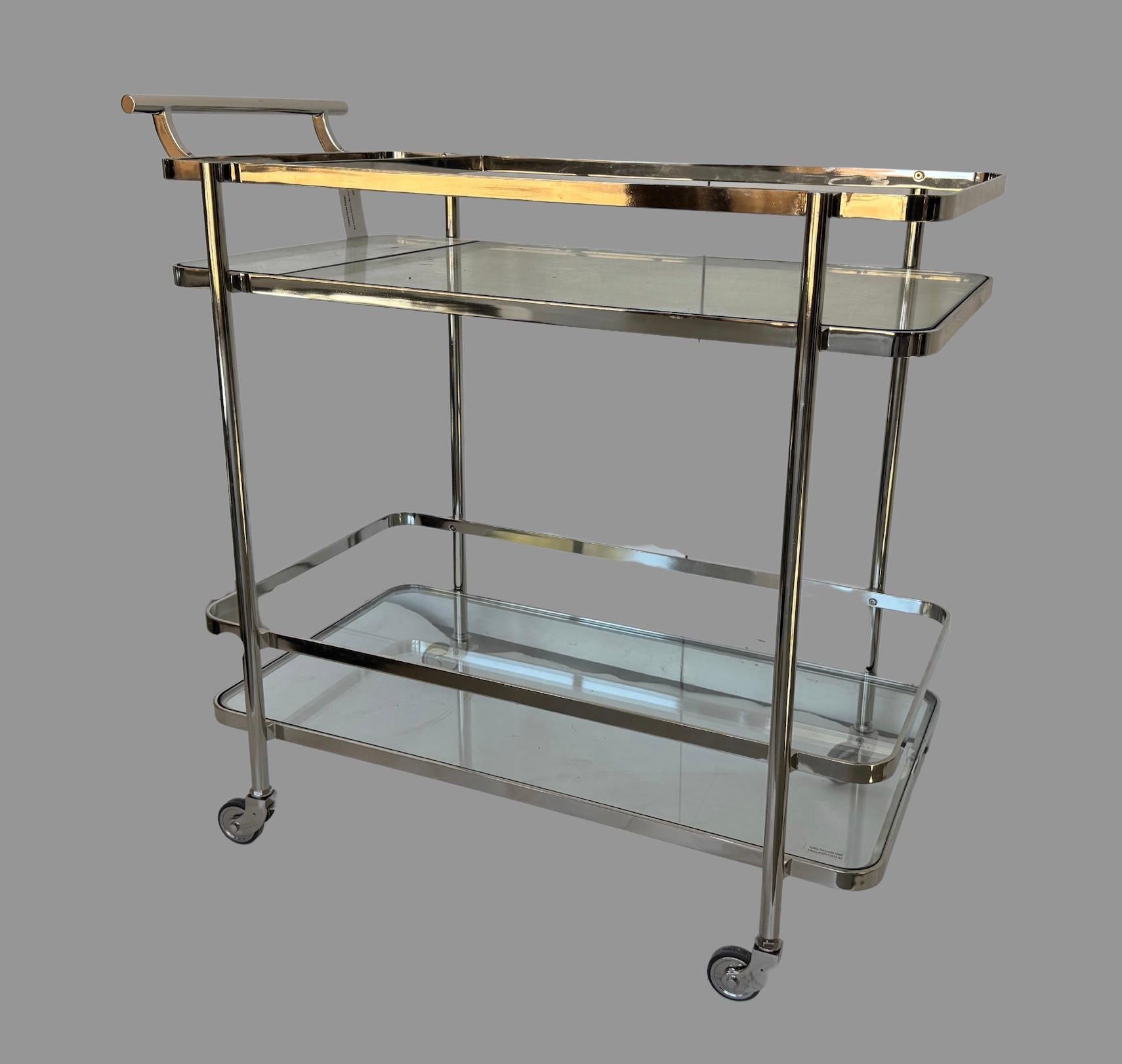 Este precioso carrito de bar está fabricado en cromo y latón.  Tiene edad, pero no se puede confirmar su antigüedad.  La báscula es perfecta para un bar seco.  se han sustituido sus inserciones de cristal.  Las ruedas son lisas y ruedan bien, y no