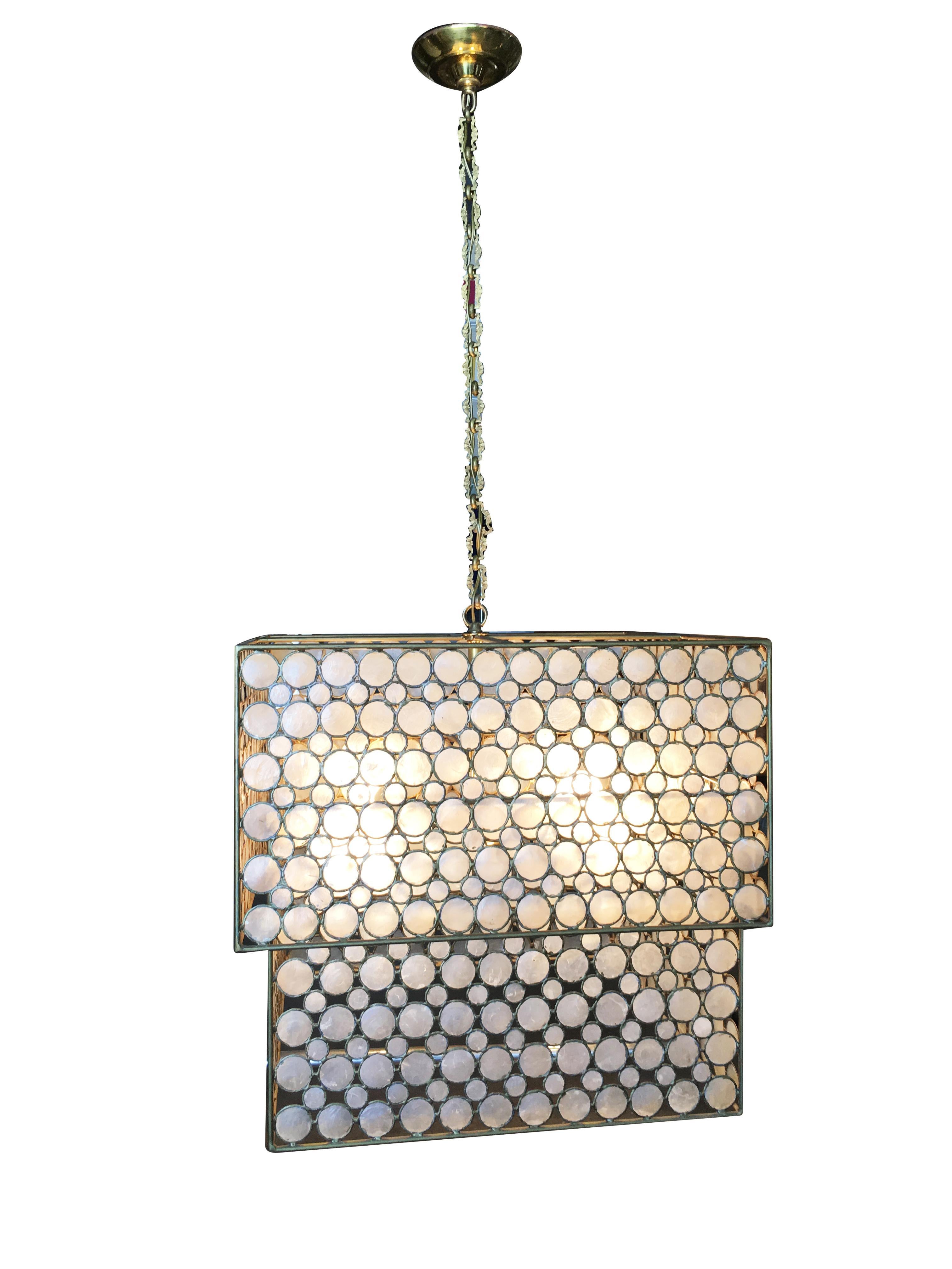 Midcentury style chandelier with double box mother of pearl brass design featuring a 2 brass frames with mother of pearl fronts.

addx1