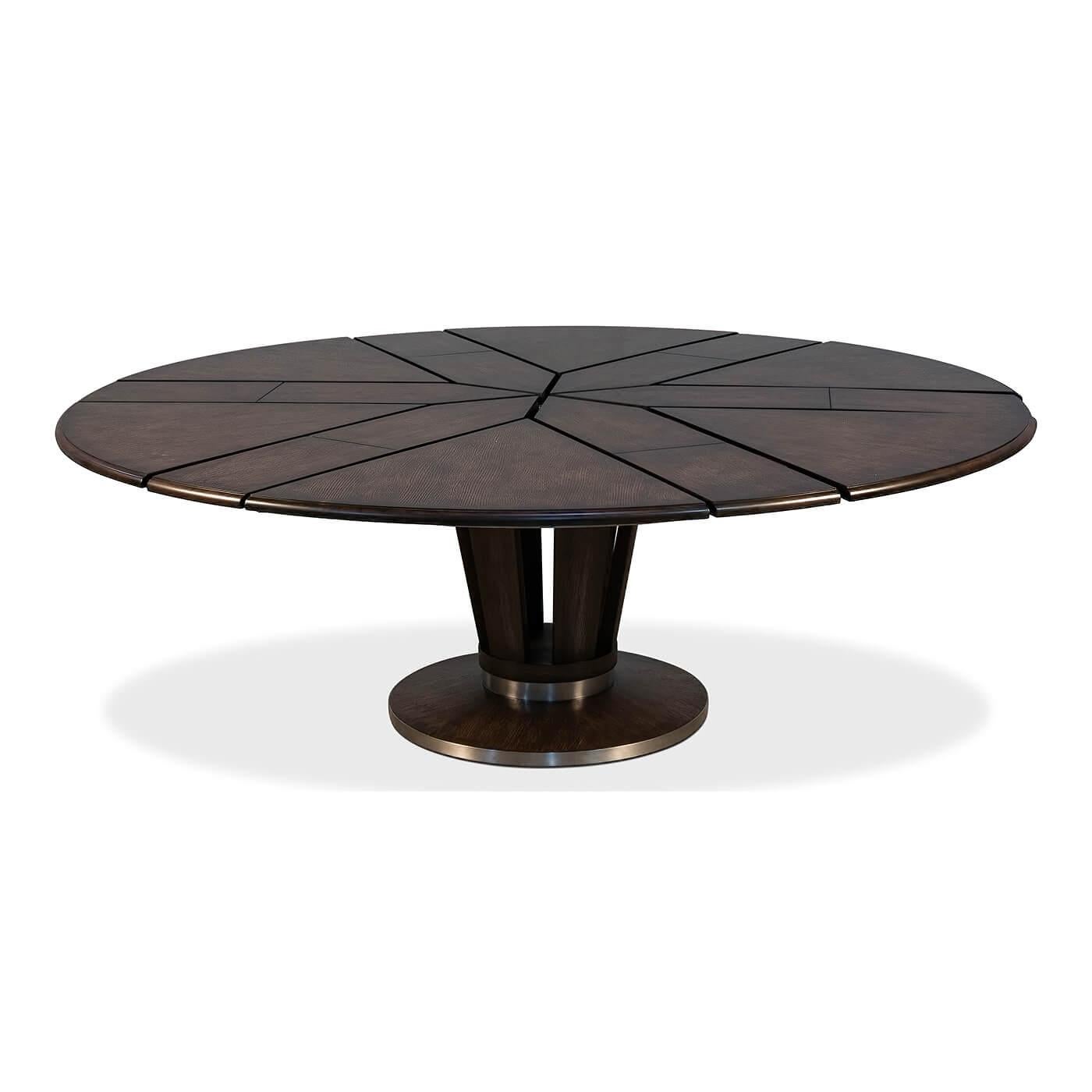 Mid-Century Modern style round extension dining table. The self-storing extension table with a dark oak stained polished top, with antique stainless steel bands to the apron and the openwork circular pedestal base.

Open dimensions: 84