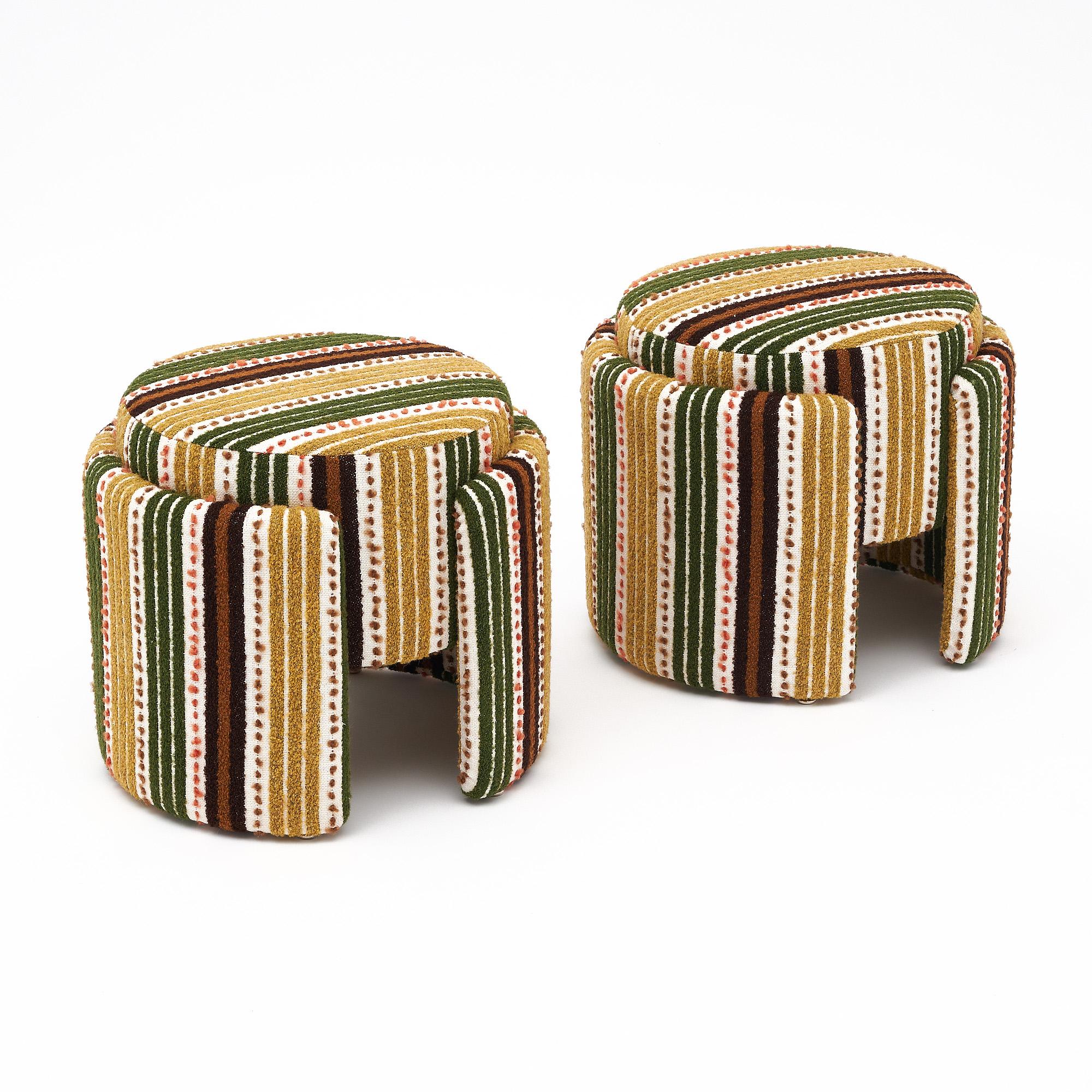 Pair of stools in the mid-century style from Italy. The stools are circular in design with curved legs on each. They have been upholstered in a Paul Smith fabric.