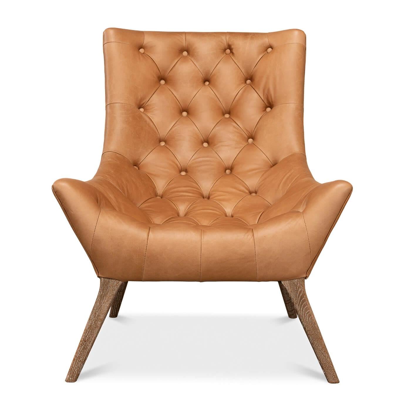 A mid-century style tufted leather armchair upholstered in light harness brown leather with splayed whitewashed oak legs. 

Dimension
32 in. W x 38 in. D x 38 in. H 
Seat: 23 in. W x 21 in. D x 16 in. H 
Arm: 20 in. H.
 