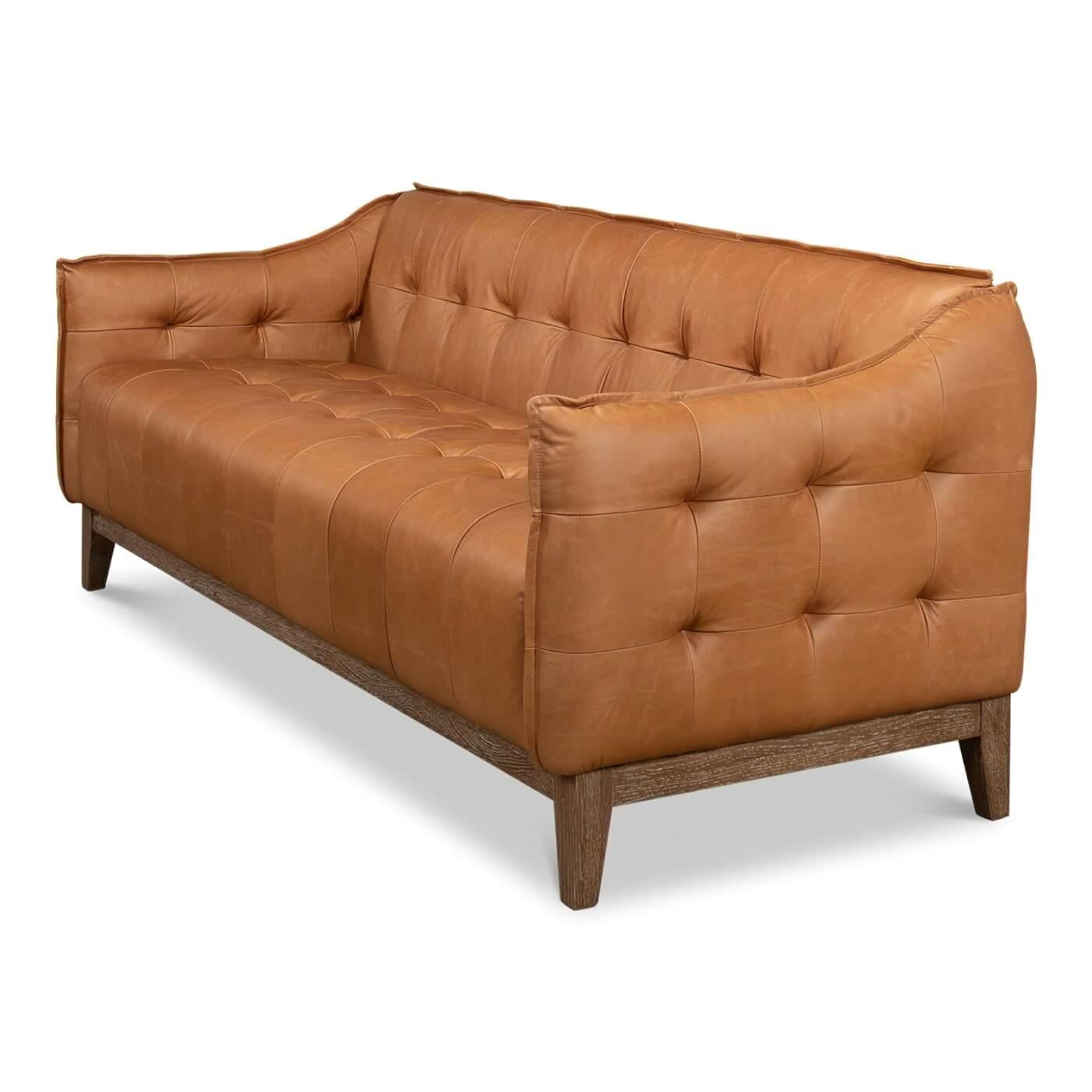 A mid-century style leather sofa with a distressed oak base. This contemporary sofa is upholstered in traditional brown leather with a button-tufted interior and sides. 

Dimensions: 77