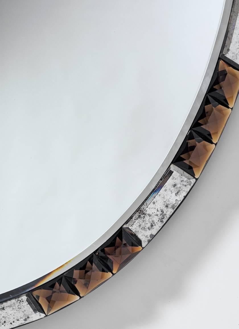 Midcentury style oval mirror with chamfered edge mounted with alternating antique crystal and topaz crystal stones. 
Measures: Height 44