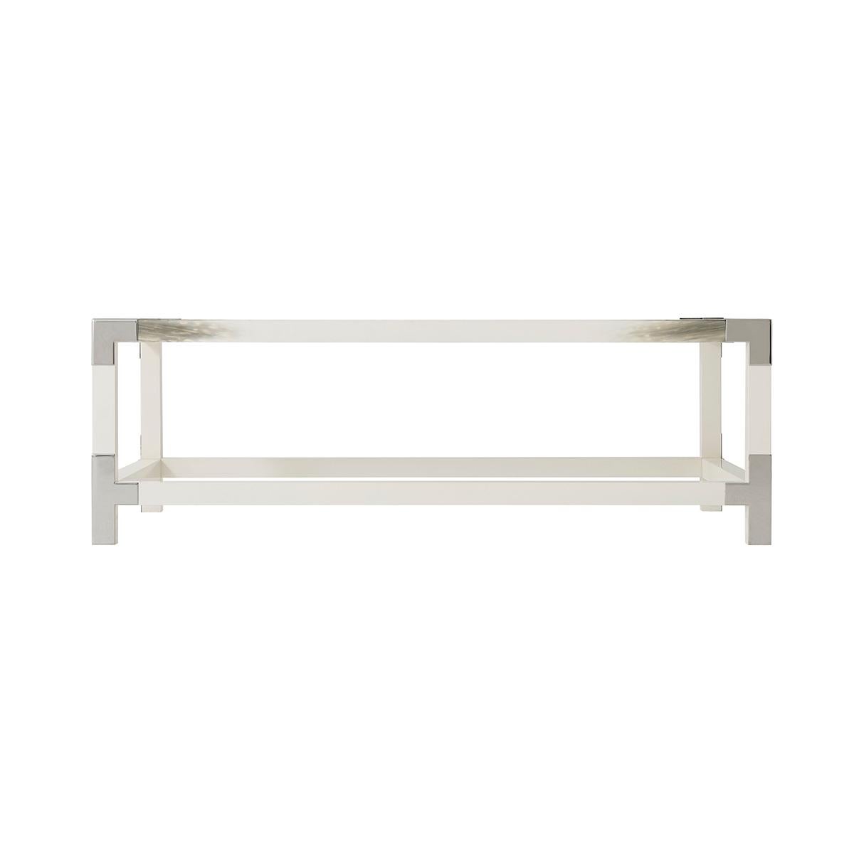 white lacquered and faux horn painted cocktail table, the rectangular glass inset top with brass edged corners, on square legs joined by stretchers.

Dimensions: 54