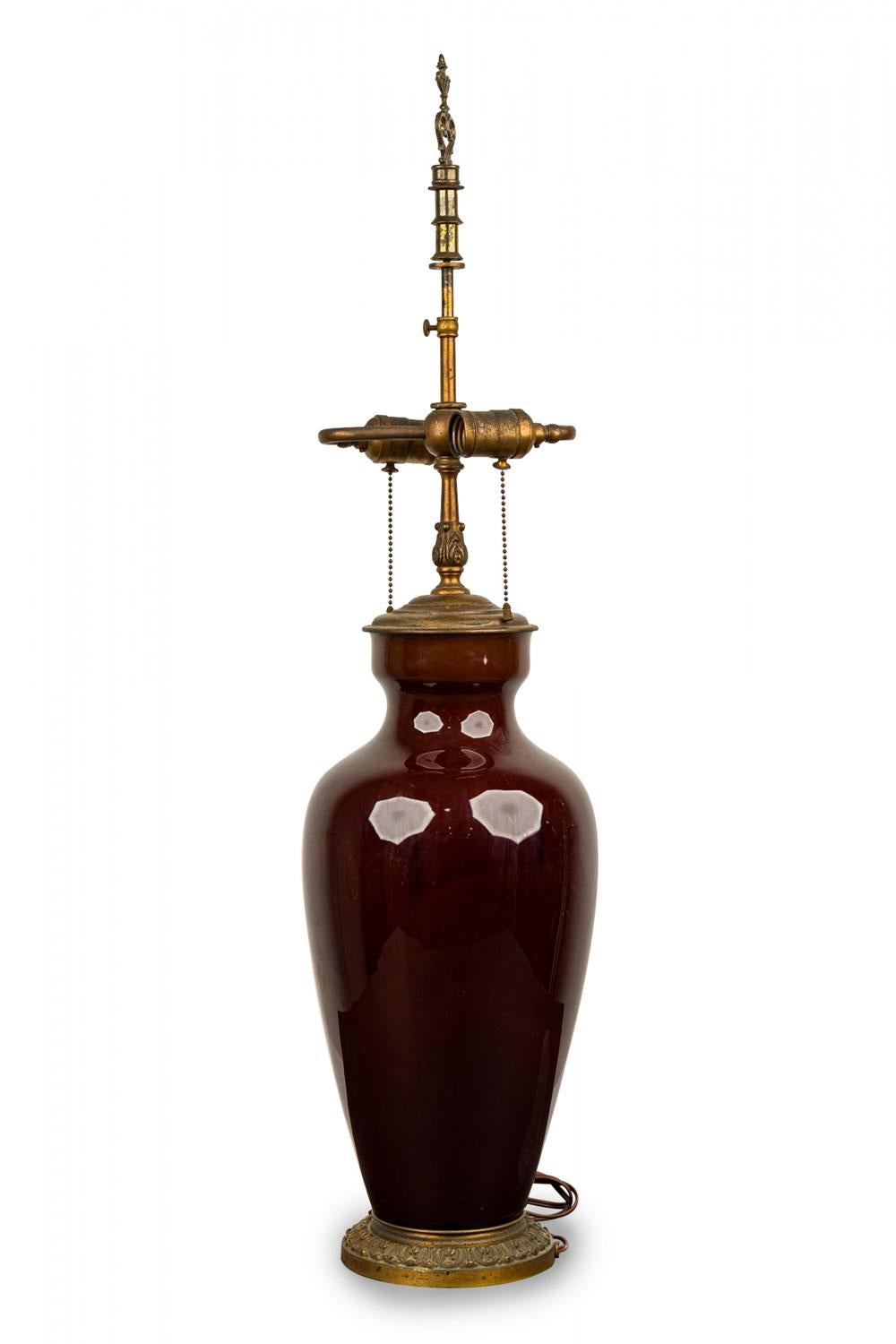 Cuerpo en forma de jarrón de mediados de siglo, apoyado sobre una base circular de latón con patas y montado con herrajes de latón.