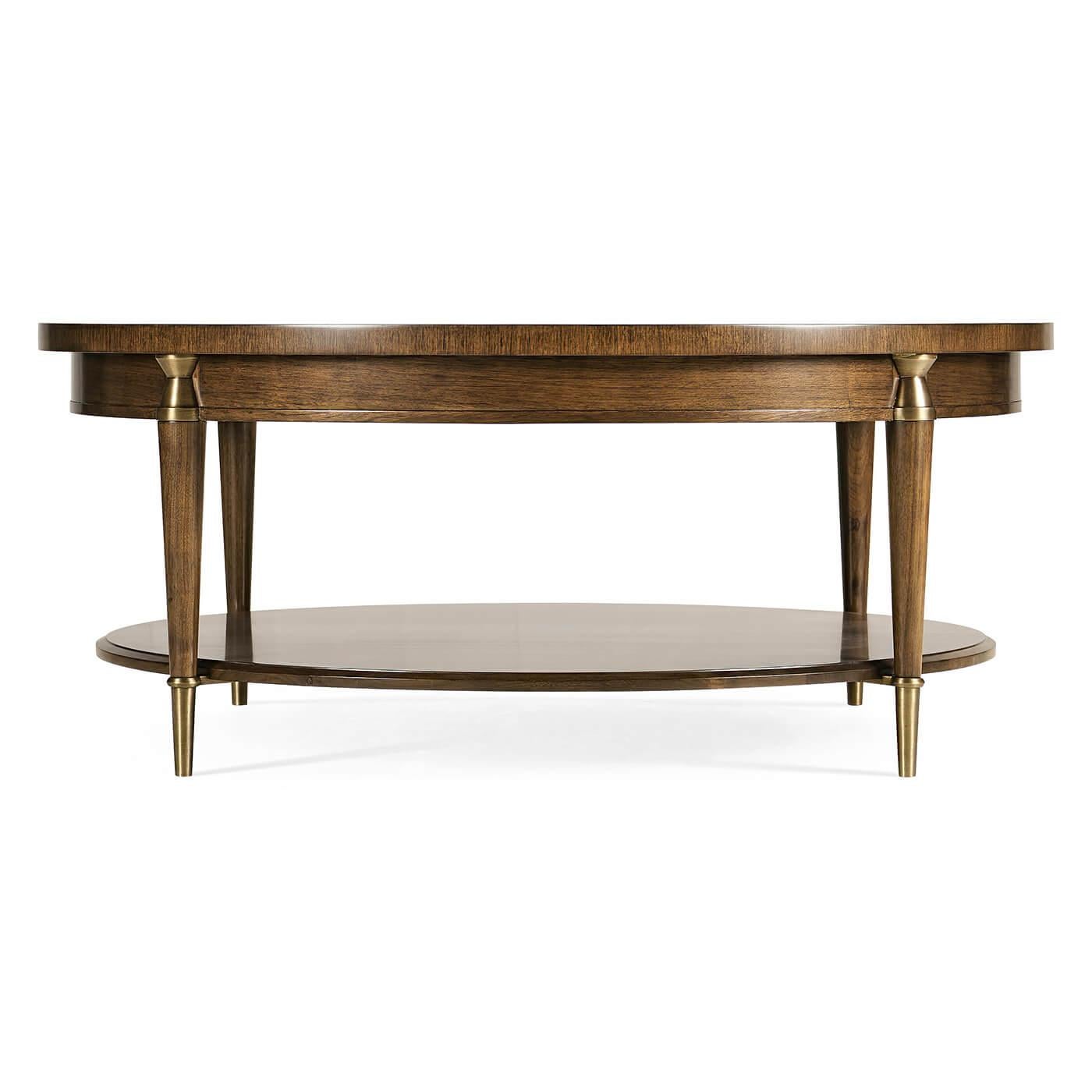 Mid-Century Modern round coffee table. Influenced by the work of the French Modernists, this table features figured walnut veneer, in a radial slip match pattern. Legs are solid walnut with brass hardware. Hardware is cast and acid dipped then