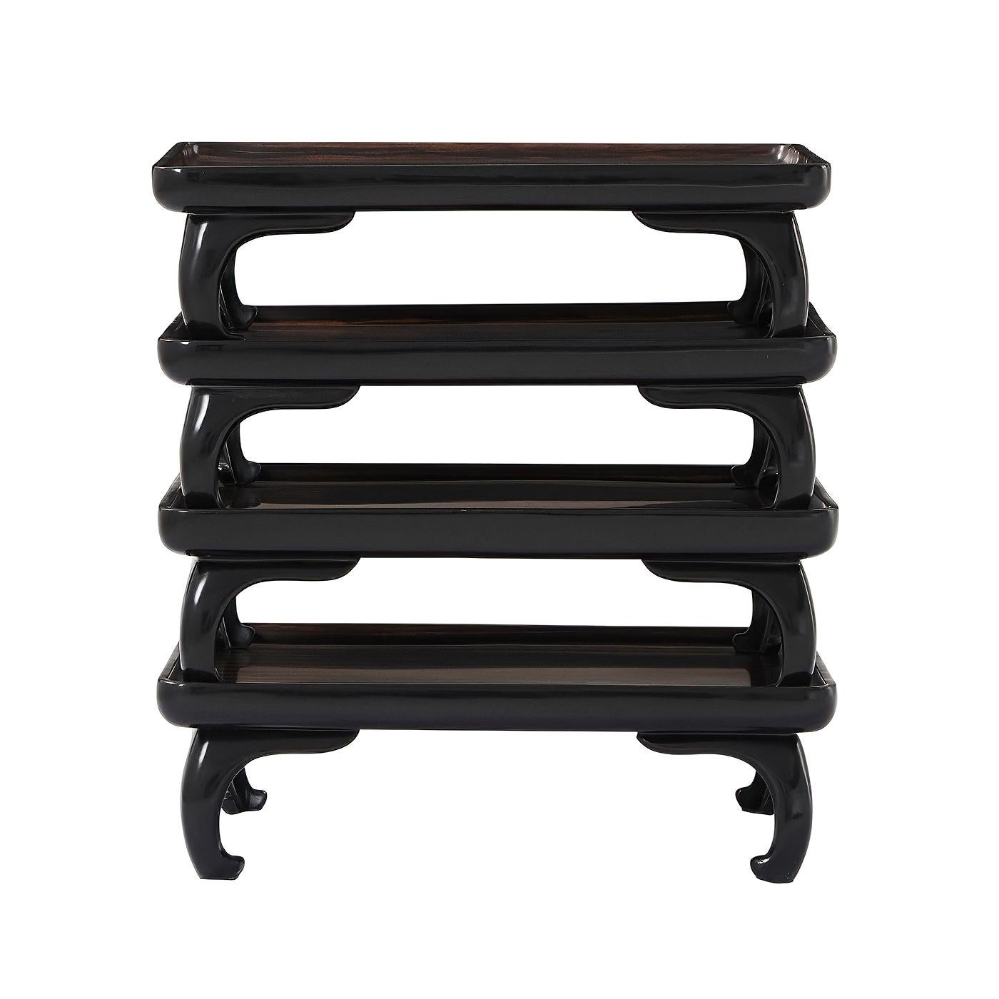 A Mid-Century Modern style Chinese stack of four movable trays with Amara veneered dish tops and each set on ebonized Chau bases. 

Dimensions: 17