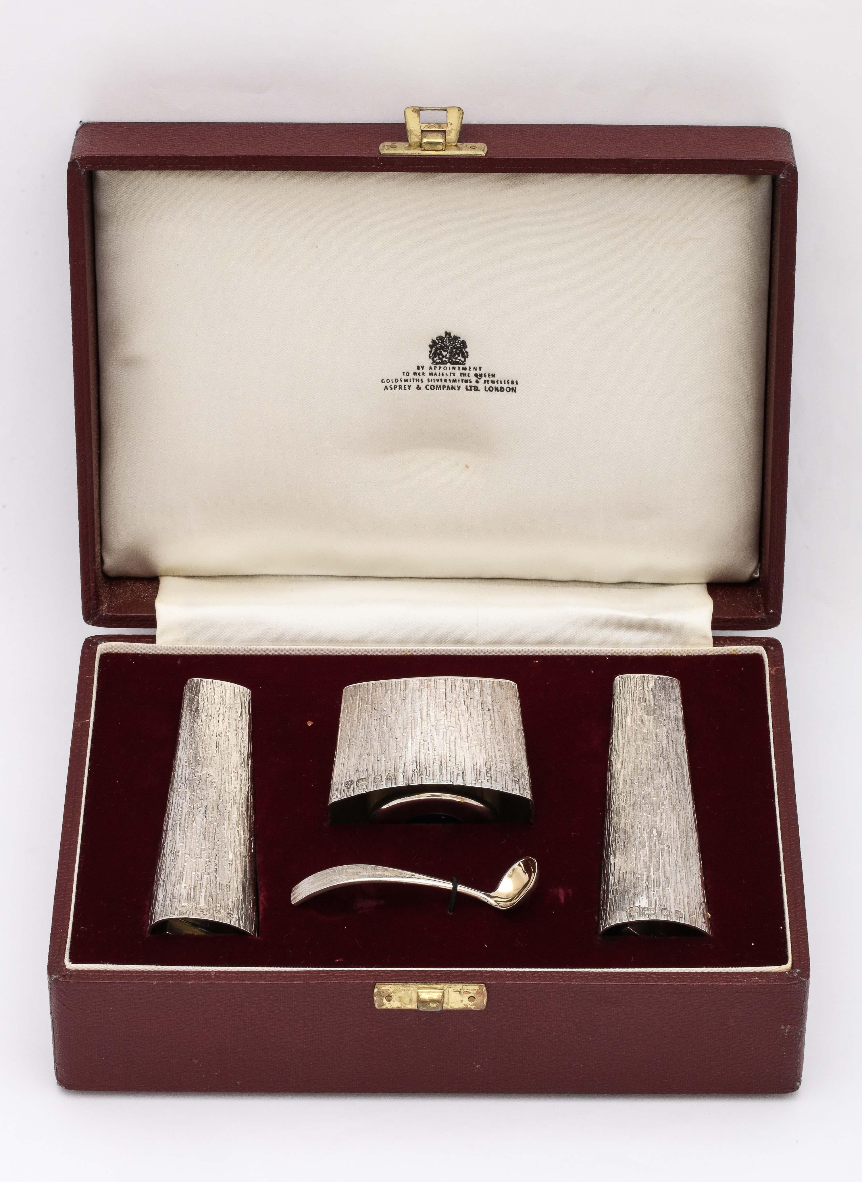 Mid-Century Modern style sterling silver condiments set in original box, consisting of a pair of salt and pepper shakers, an open mustard cellar and a matching mustard spoon, London, year hallmarked for 1971, Asprey and Company, Ltd. - makers.