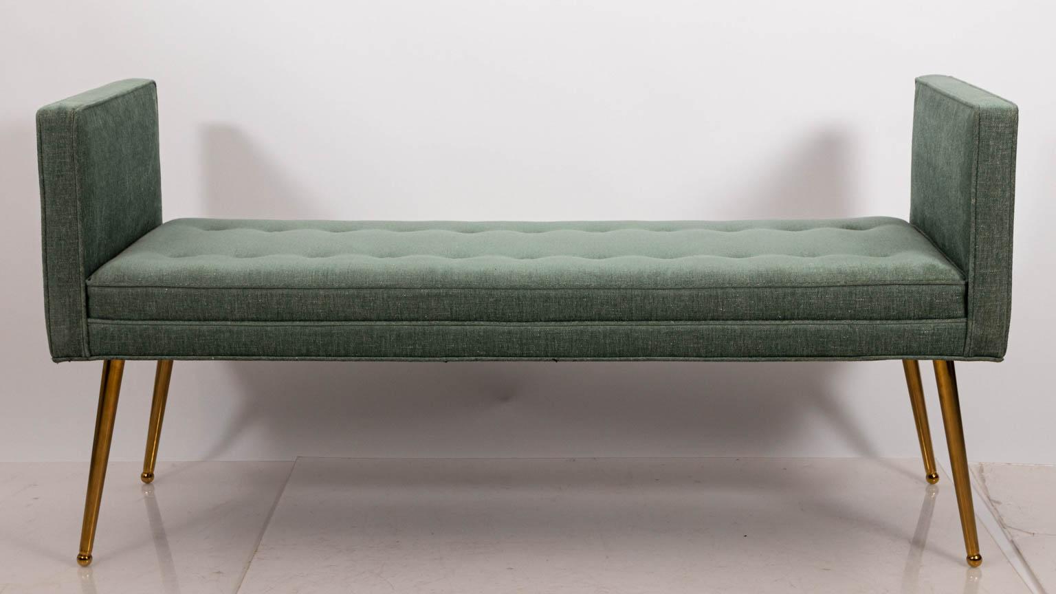 Two arm midcentury style bench with brass legs, circa 21st century. The piece also features tufted seats. Please note of wear consistent with age. Made in the United States.