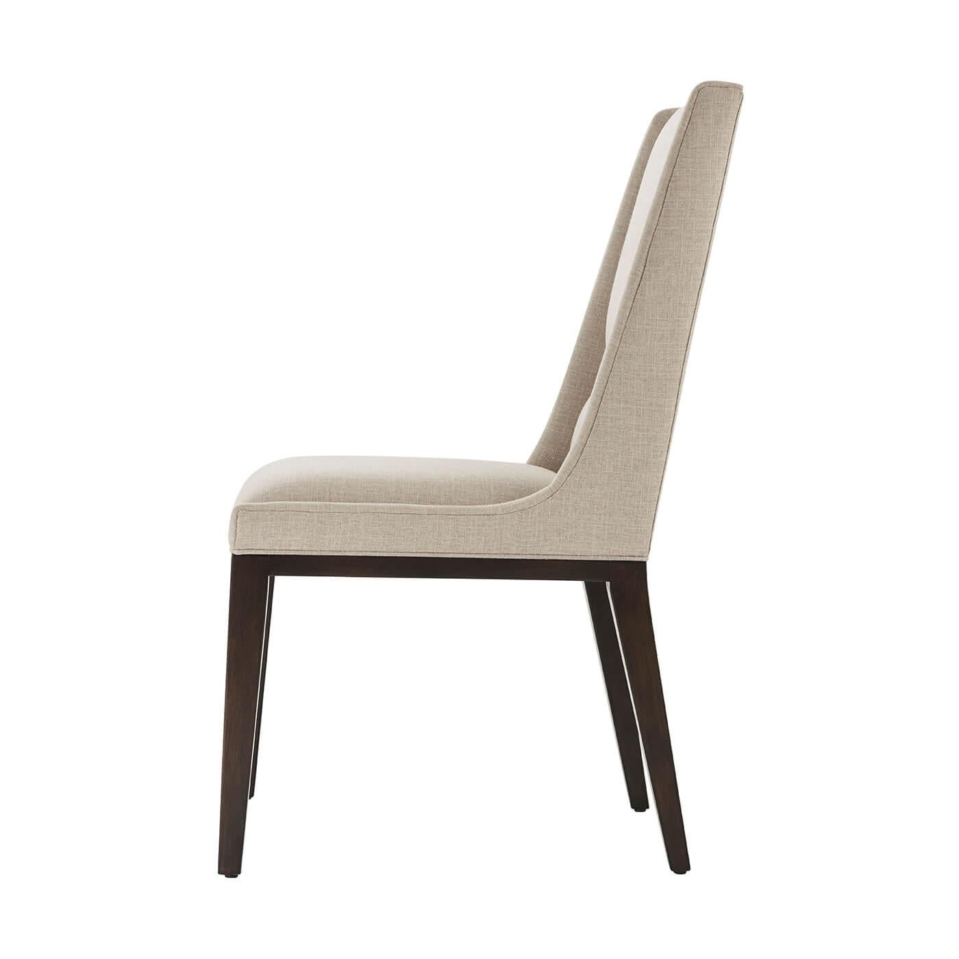 A mid century style upholstered square back dining chair in our Ossian finish, with a panel upholstered backrest and tight upholstered cushion seat and raised on square tapered legs.

The upholstery is a treated performance fabric to protect from