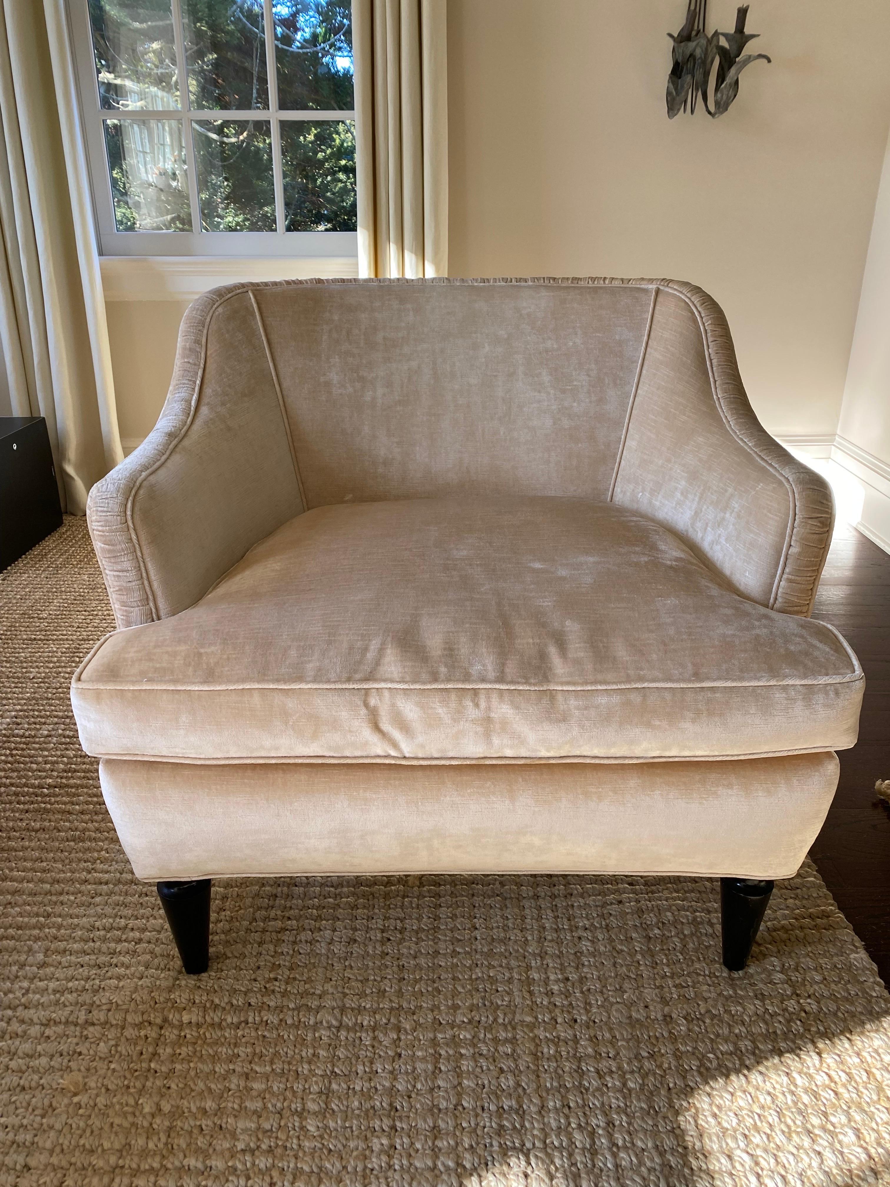 Mid-Century Style Velvet Upholstered Armchair with Black Painted Legs.
A low profile club chair with interesting lines and details. Upholstered in an eggshell cream velvet with ruched flat banding along the top of each arm and seat back. Interesting