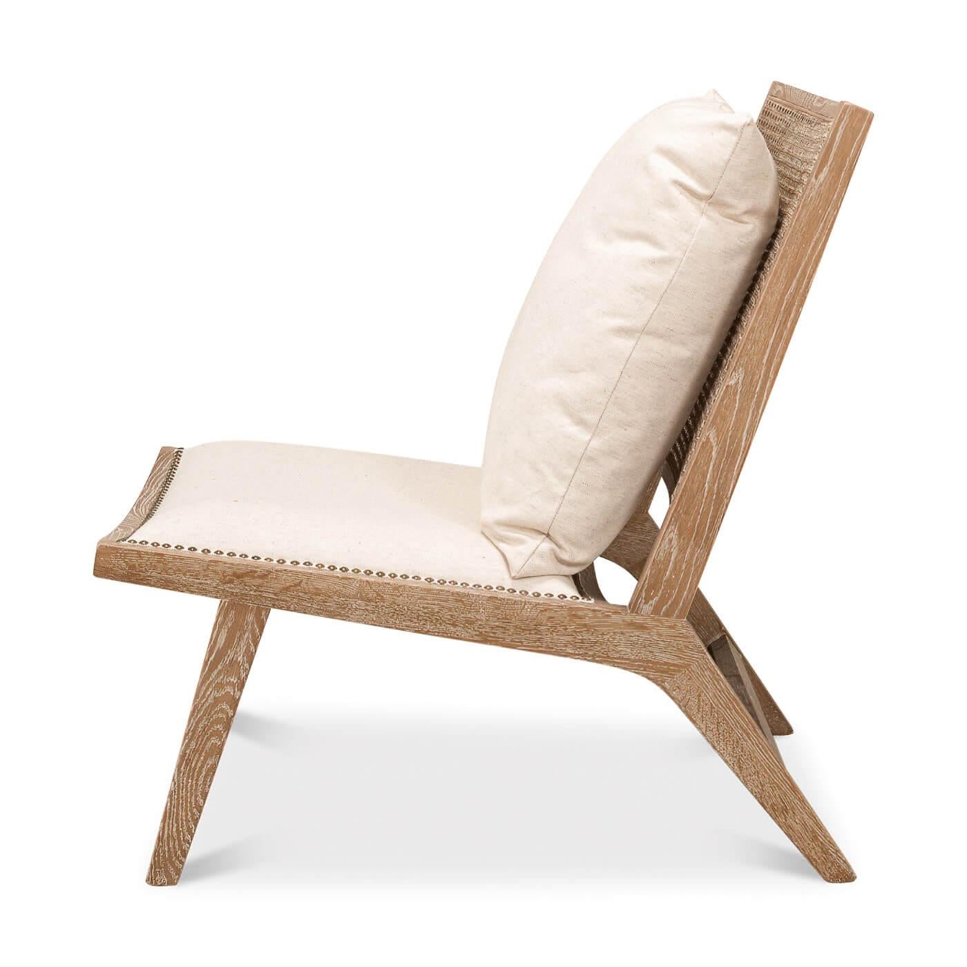 Ein Stuhl im Mid-Century-Stil mit weiß gekalkter Rohrrückenlehne und gepolstertem Sitz aus Leinen, der mit Nagelkopfleisten verziert ist. Es enthält ein loses Kissen für den Rücken. 

Abmessungen: 25