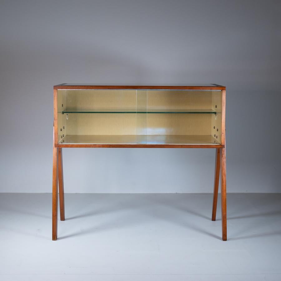 This elegant 1950s Mid-Century style wooden display case represents an example of mid-century design. Made from high-quality wood, this display case features clean lines and sturdy construction that reflect the functional, minimalist aesthetic of