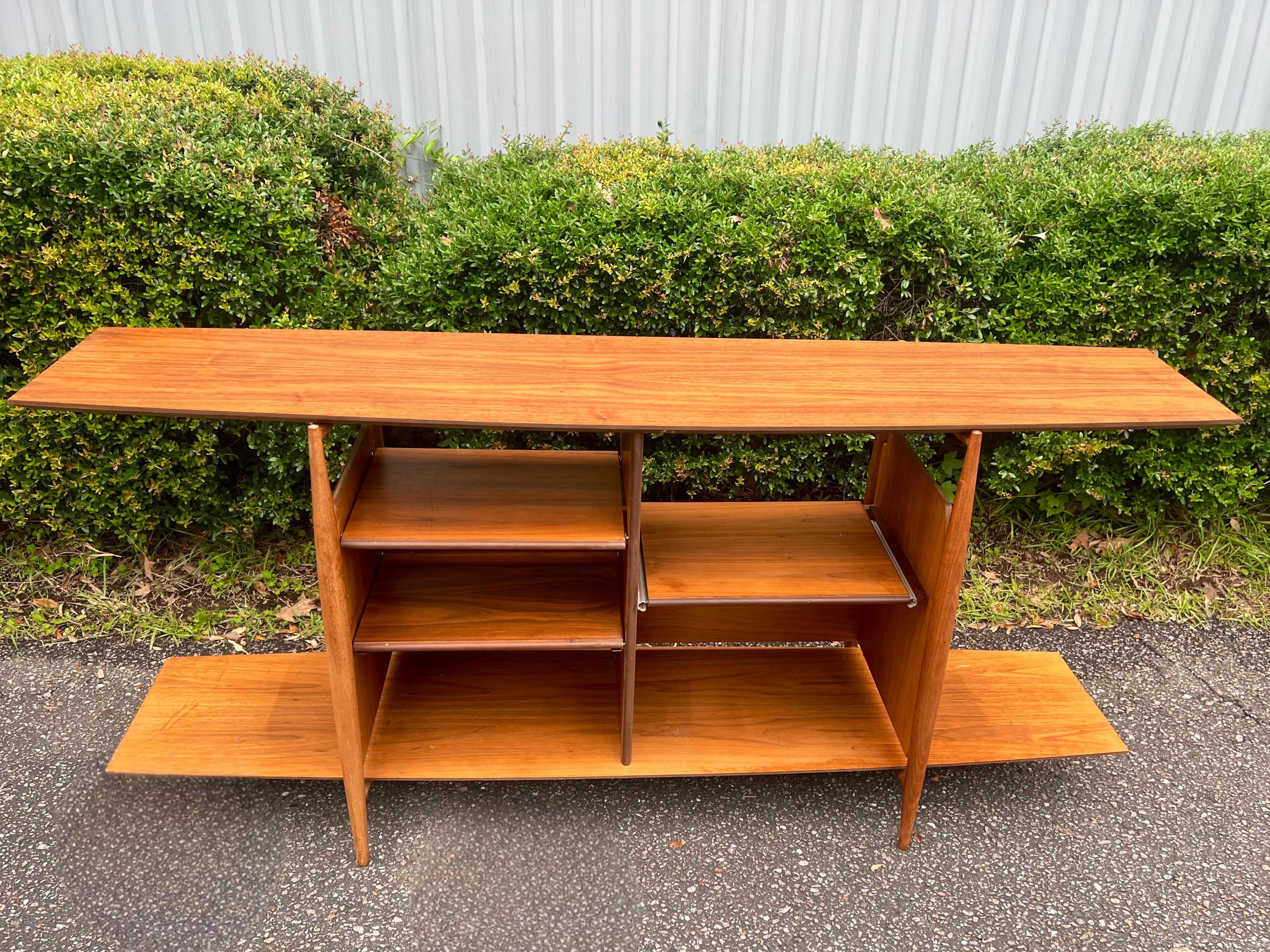 Fascinating two-tier bookshelf designed and manufactured in the United States circa 1960’s. This Mid-Century Modern piece offers plenty of room for storage making it versatile enough to be used as an entry way console as well. It suits any interior