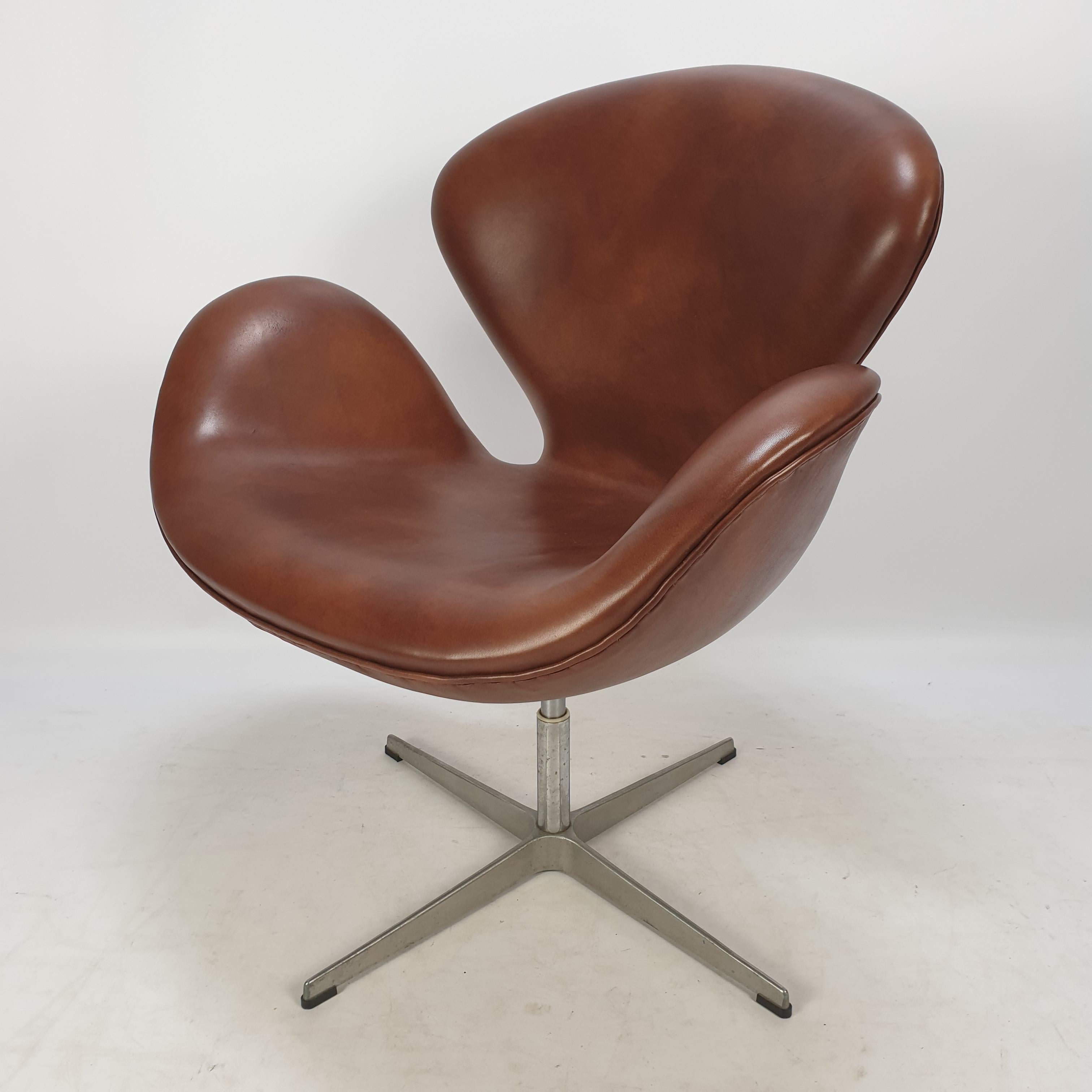 Beautiful brown leather Swan chair. Produced by Fritz Hansen in 1980 (see the label) and designed by Arne Jacobsen in 1958 for the SAS Royal Copenhagen Hotel. This is a very special and rare edition, it is possible to change the seat hight from 41