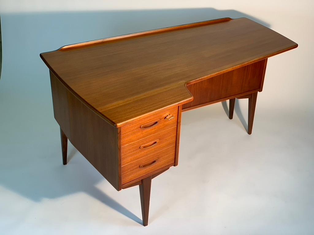 Model A10 desk designed by Göran Strand for Lelångs Möbelfabrik in Sweden in the early 1960s.
This model in teak wood has a very particular shape of the top, deeper on the left side where there are three drawers with handles carved in solid wood,