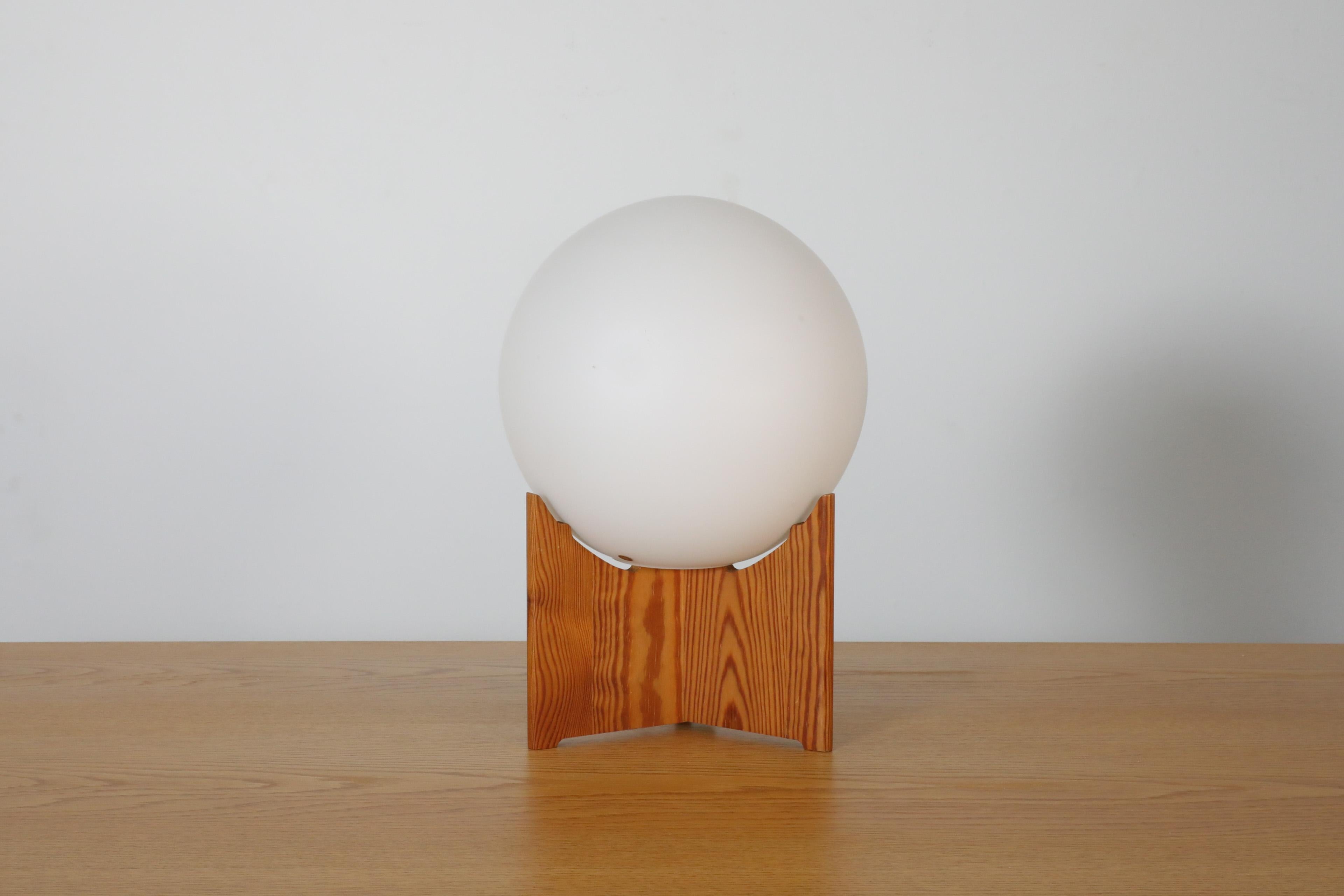 Mid-Century AB Markaryd table lamp with pine base and milk glass globe shade by Hans-Agne Jakobsson. Stylish table lamp with lovely carved wood base and unattached globe shade. In original condition with visible wear consistent with its age and use.