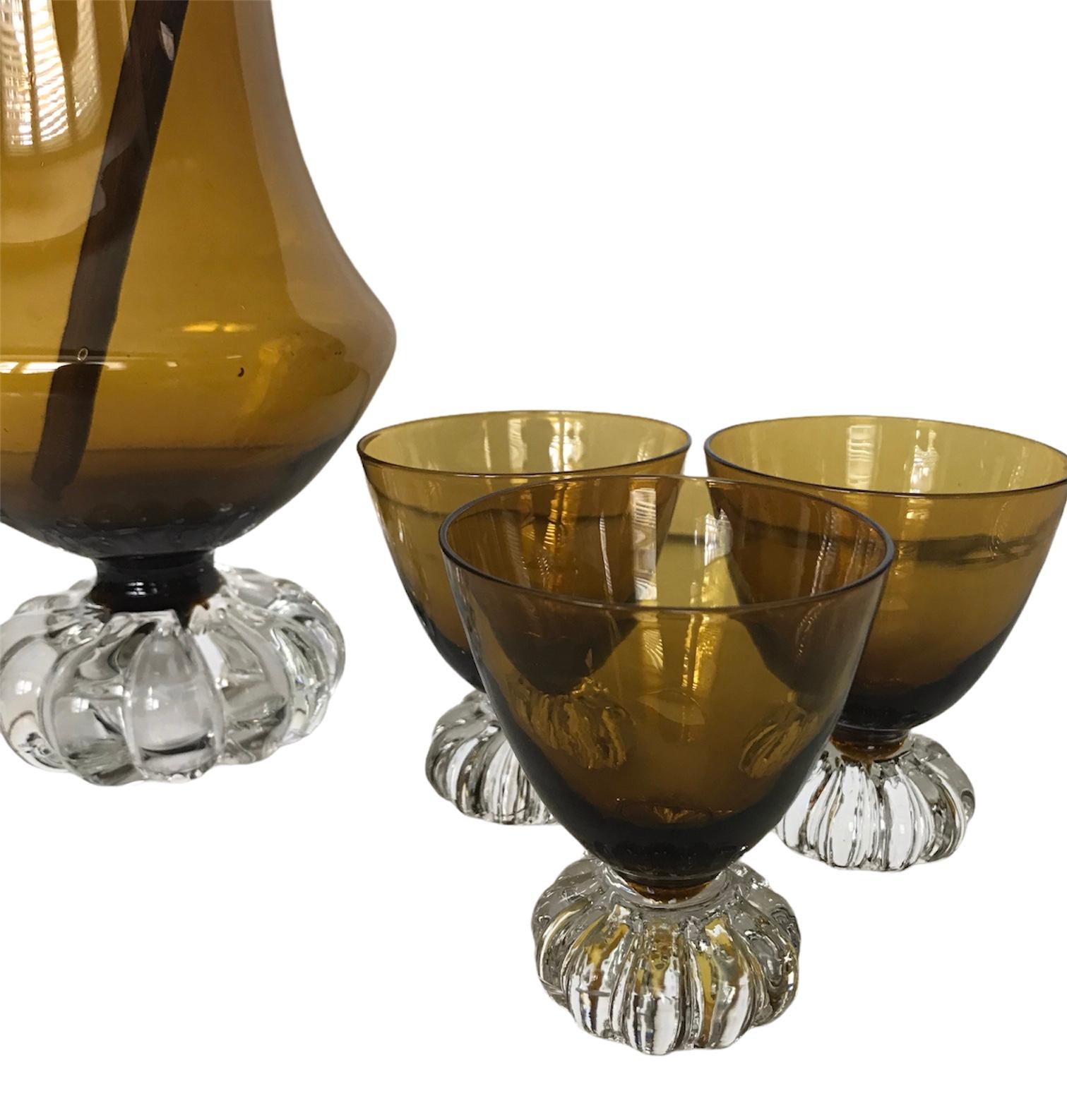 Such a strikingly, beautifully designed Amber colored glass barware set by Bo Borgström for Aseda Glasbruk of Sweden. Both the pitcher and glasses offer a scalloped edging with a weighted bottom. These stunners will impress your party goers.