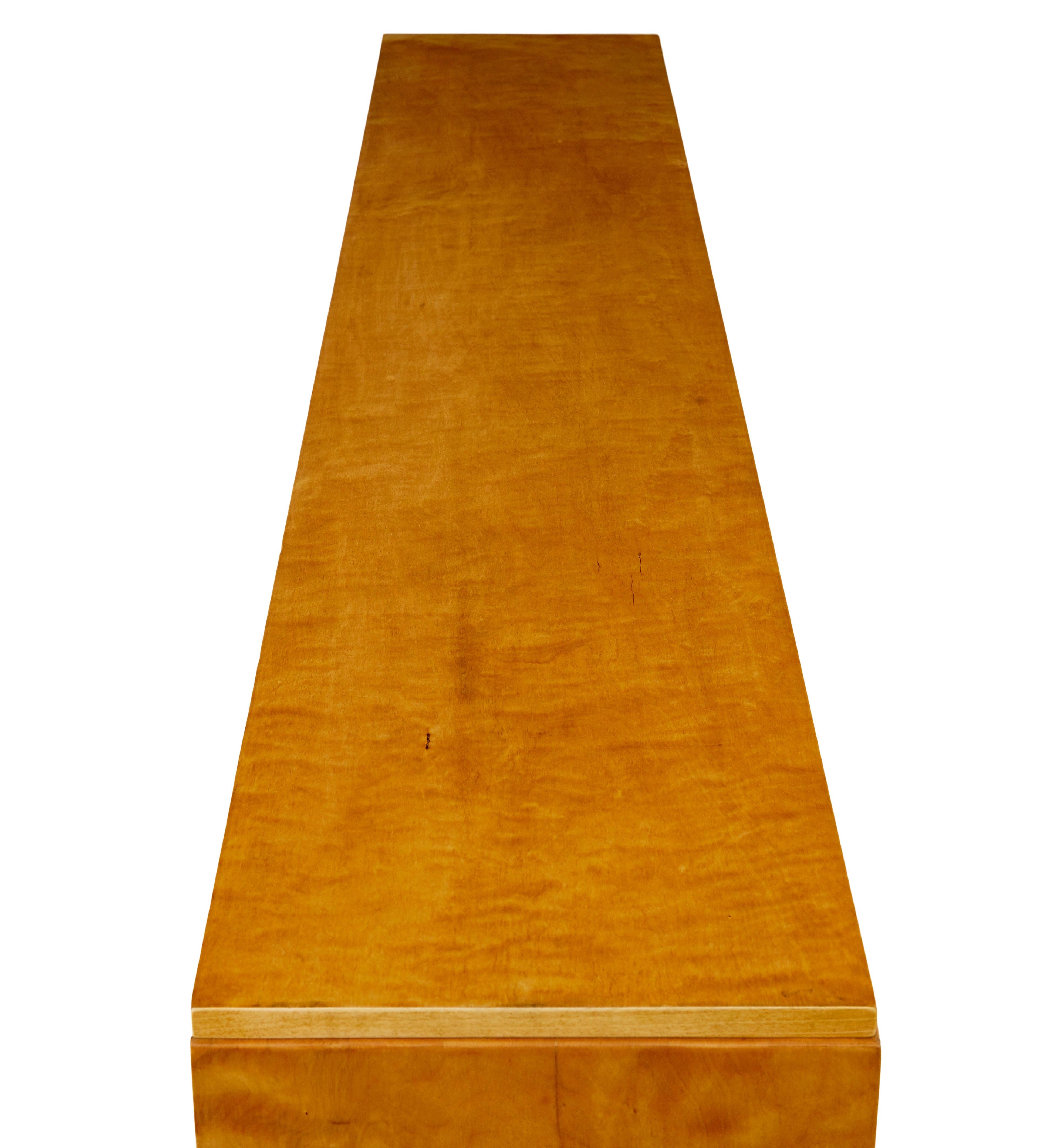 Schwedisches niedriges offenes Bücherregal aus Birke aus der Mitte des Jahrhunderts, ca. 1950.

Hochwertiges Bücherregal aus skandinavischer Birke aus der Mitte des Jahrhunderts mit Schränken.

Abgestufte Platte mit 3 Schubladen unter der