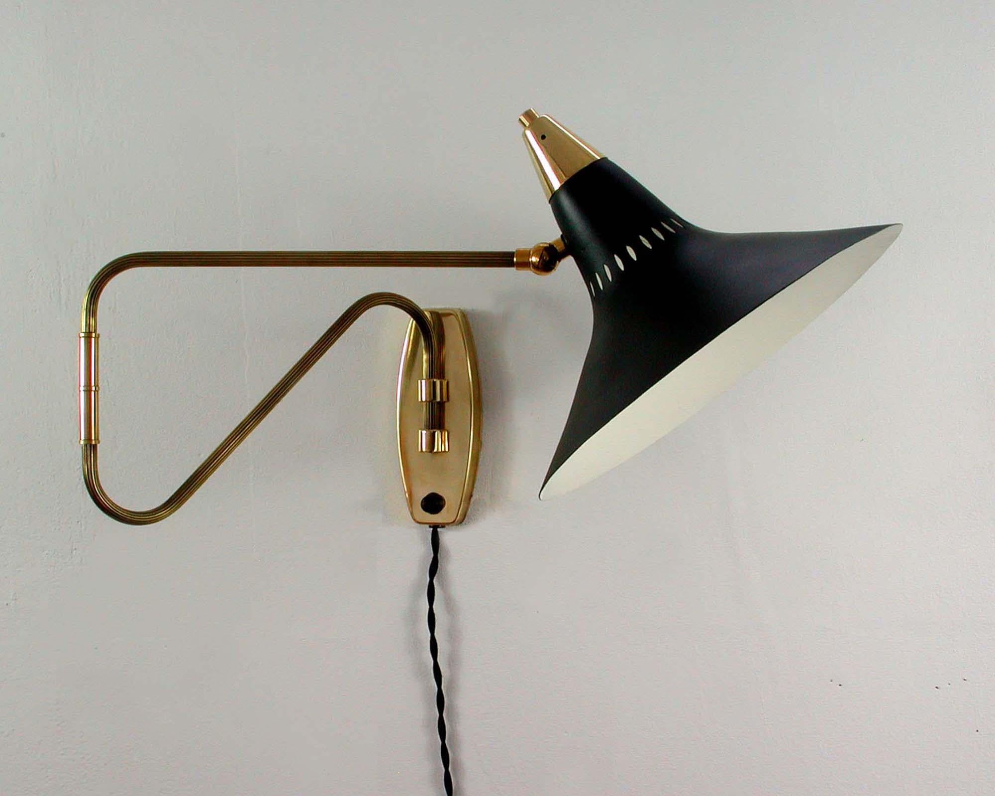 This 1950s articulating wall lamp was designed and manufactured in Sweden.

The wall light has got a black witch hat shaped lampshade and brass swiveling lamp arm with brass details and a brass wall fixture. The lamp has been rewired and we have
