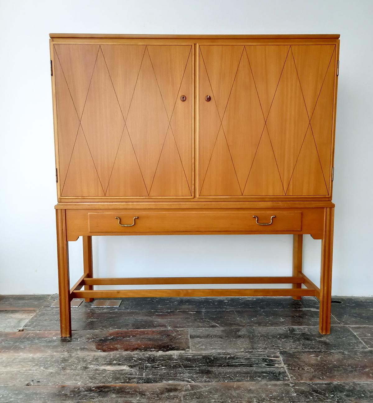 Mid-Century, Scandinavian Modern, Design Classics. 
A stunning cabinet in two-tone birch and walnut designed by Carl-Axel Acking for Nordiska Kompaniet, Sweden 1940s. Comes with a key.

Nordiska Kompaniet.
Stirred by the eye-catching grandeur and