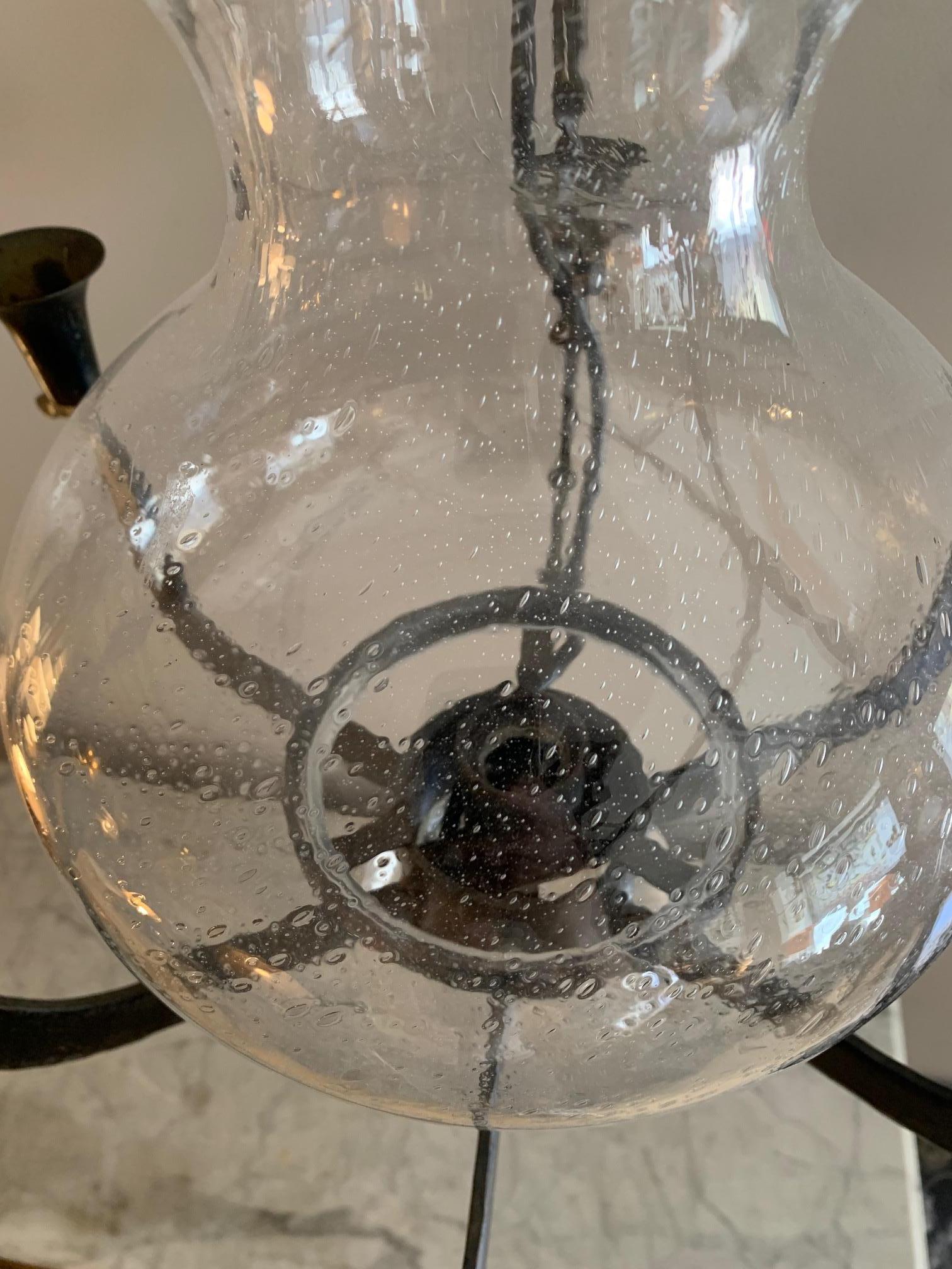 Swedish ceiling lamp from the middle of the 20th century, attributed to the designer Rolf Sinnemark, the lamp is made of iron with six arms for candles, the central part is a glass globe with a socket for a light bulb, it combines the traditional