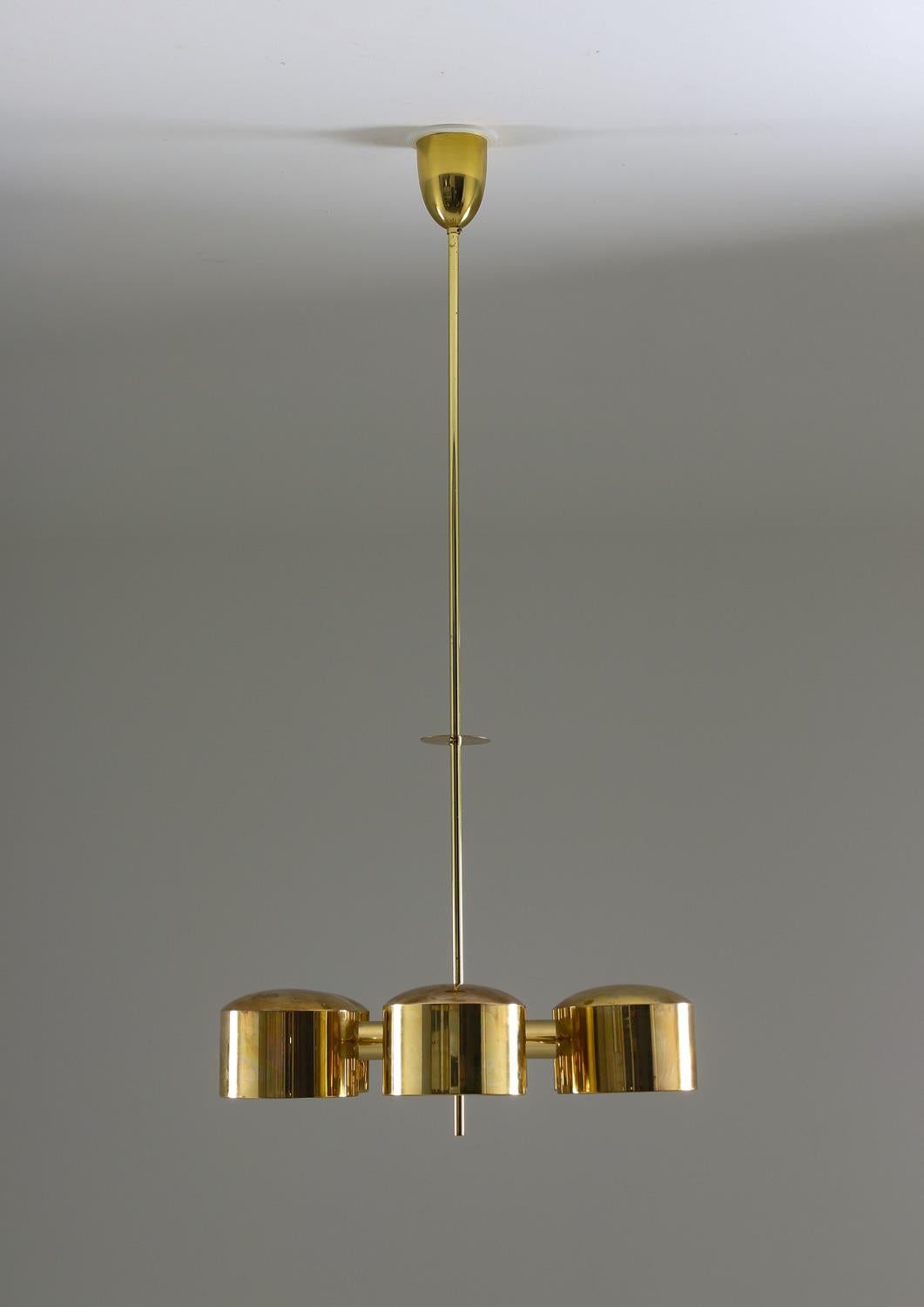 A magnificent and rare chandelier in brass by Hans-Agne Jakobsson, Sweden, 1960s-1970s.

The lamp features six light sources. Each bulb is surrounded by a circular brass shade. The shades are separated by round brass bars, creating a circular